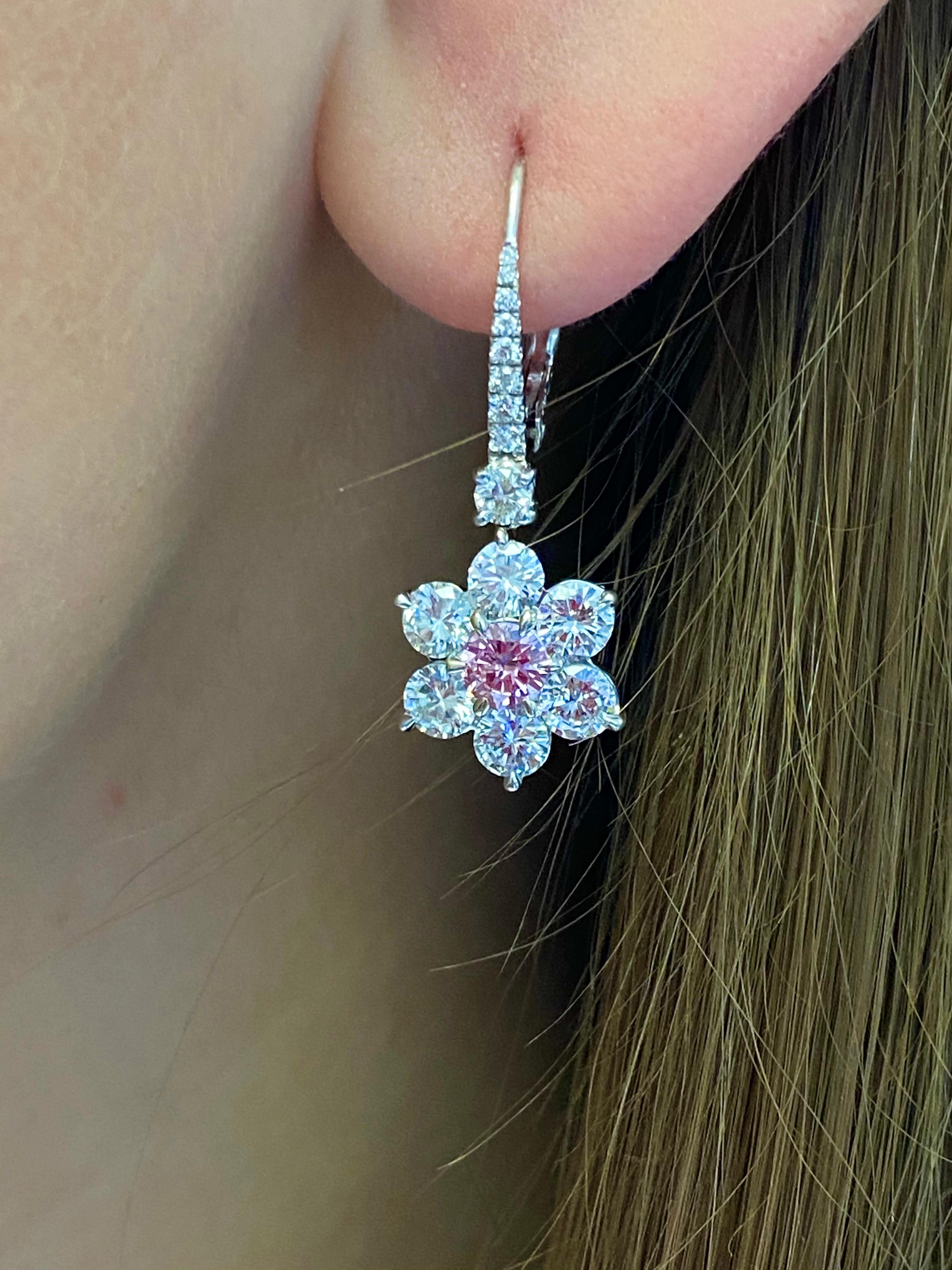 Nally Intense Purplish Pink and White Diamond Earrings.
This pair of earrings has 2center round brilliant diamonds weighing 0.56 carats  Fancy Intense Purplish Pink color &  GIA certified surrounded with 3.66ct of round brilliant diamonds set in