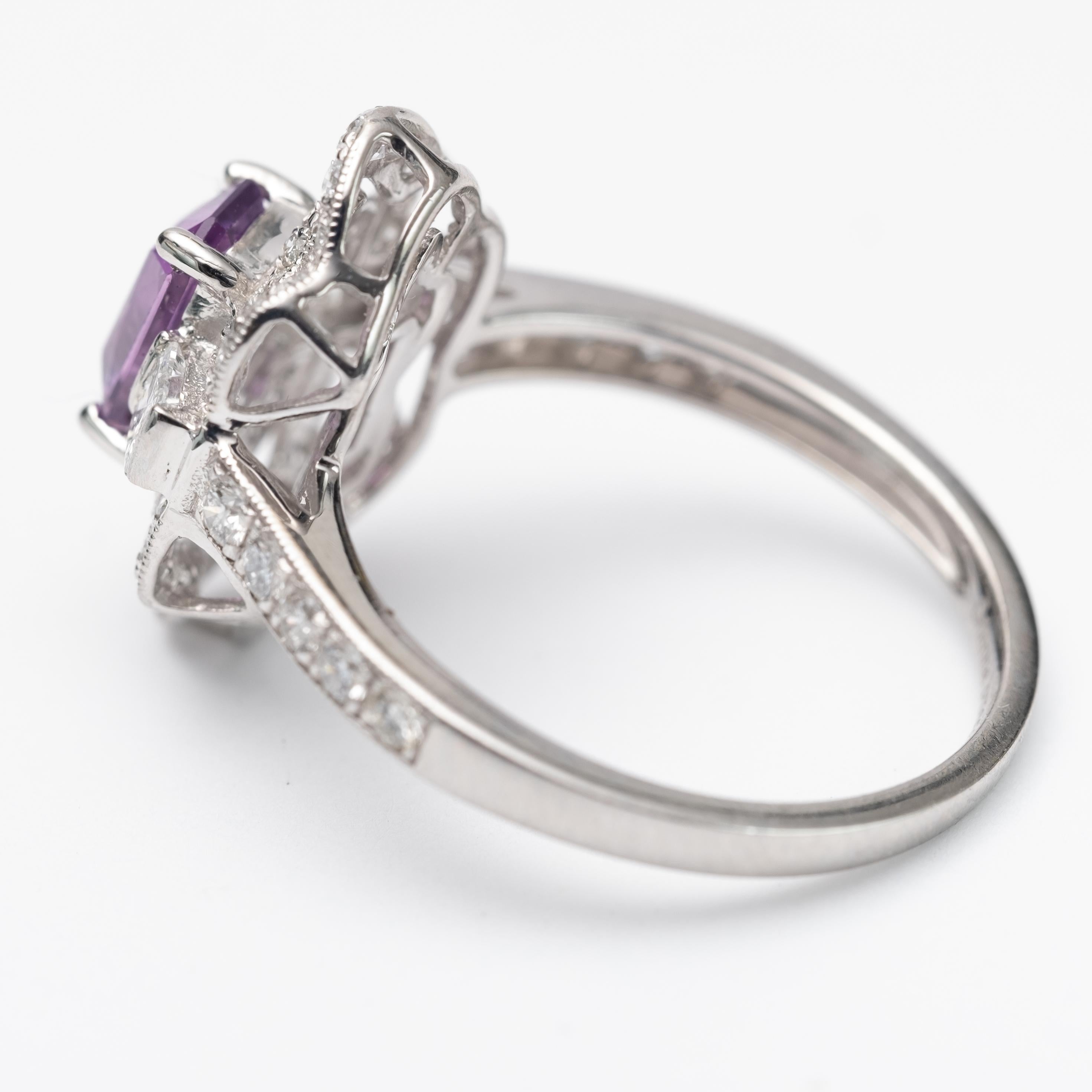 Tested platinum ladies cast pink purple sapphire & diamond ring. New Condition. The feathered sapphire is set within a tiered diamond bezel, supported by a ribbed under gallery and diamond set shoulders, completed by a combined one & one half