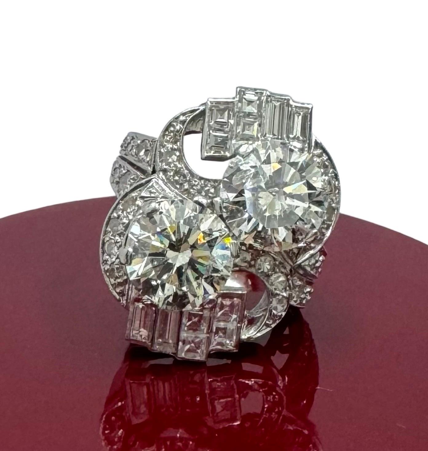 A rare and captivating collector’s piece, this vintage Art Deco bypass ring is masterfully crafted in platinum and set with two exceptional 3.00 carat round brilliant natural diamonds, offering a total center weight of approximately 6.00 carats. The