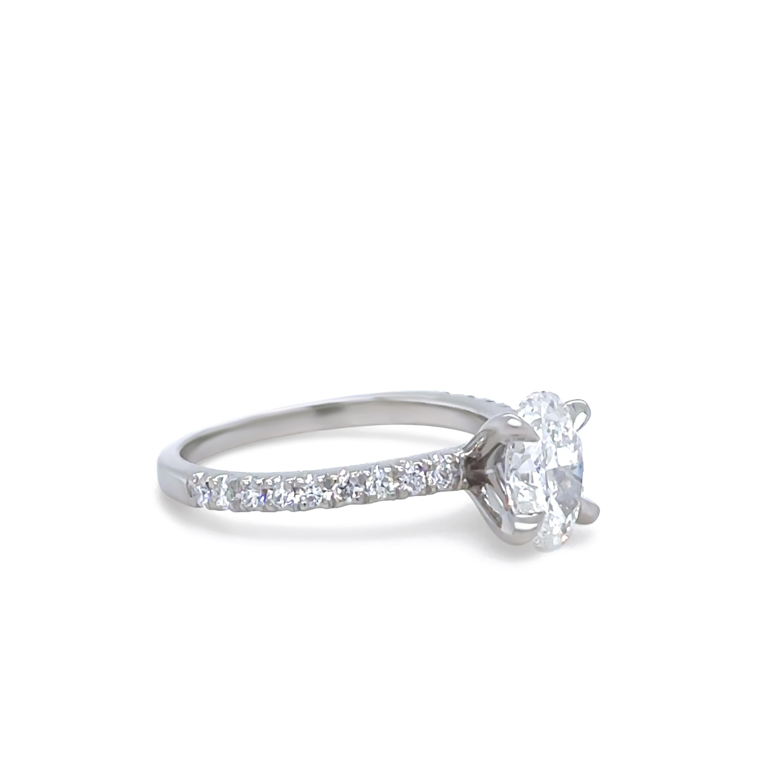 An elegant platinum diamond ring, featuring a GIA Certified 1.00ct oval brilliant-cut diamond, graded F colour and SI2 clarity (GIA Report Number 7361719668, dated 21/11/2020). This stunning centre stone is accented by 18 round brilliant-cut