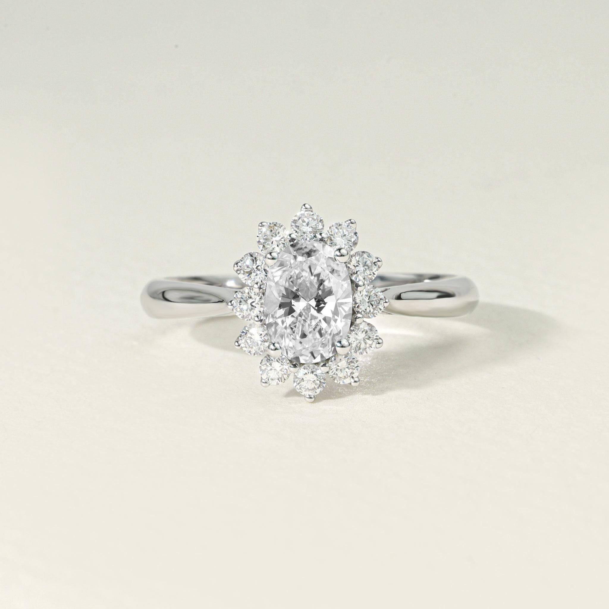 Step into timeless sophistication with this 1ct natural oval-cut diamond halo engagement ring, an exquisite embodiment of romance, refinement, and radiant design. Crafted by master artisans in 18K white gold, this heirloom-quality piece showcases a