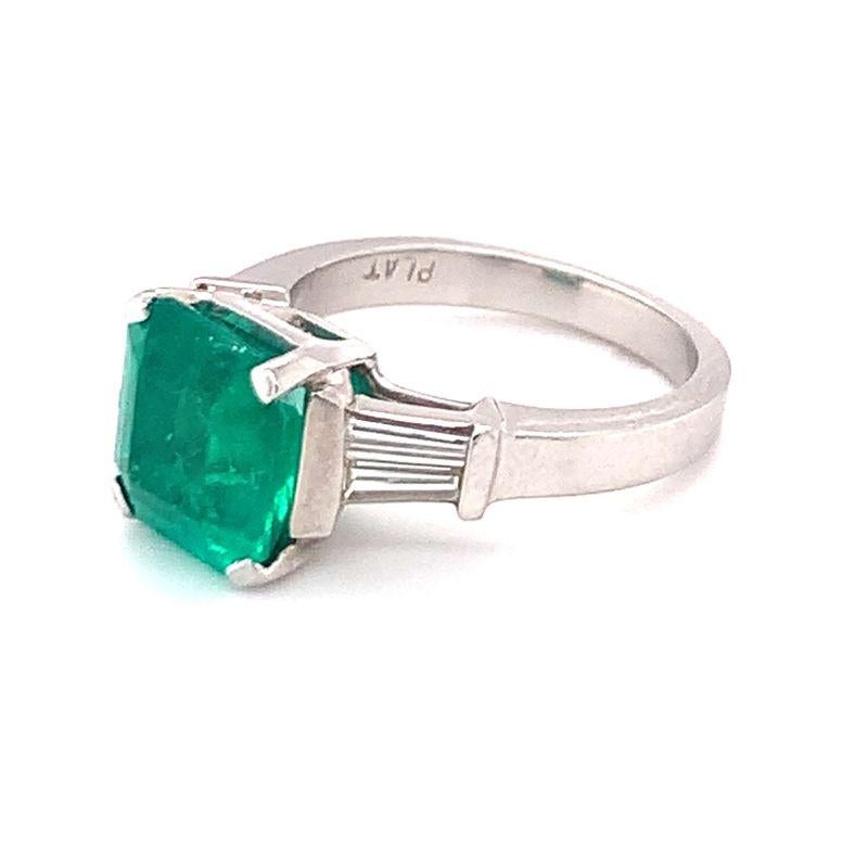 GIA Report certified Colombian emerald and diamond platinum ring centering one emerald cut emerald weighing 3.20 ct. flanked by four tapered baguette diamonds weighing approximately 0.45 ct. with F-G color and VS-1 clarity. Breathtaking, pristine,