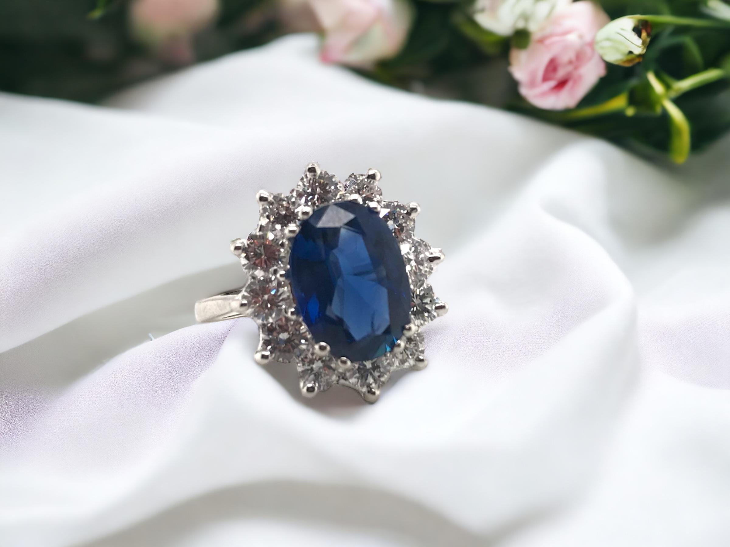 This beauty is a classic!!!
A perfect royal blue sapphire surrounded by stunning diamonds.

Ring Details
Material: 14K White
Head Length: 16.6mm
Head Width: 15.0mm
Head Height: 8.6mm
Shank Width: 1.8mm
Weight: 4.6 Grams
Finger Size: 5 1/2 
Sizable
