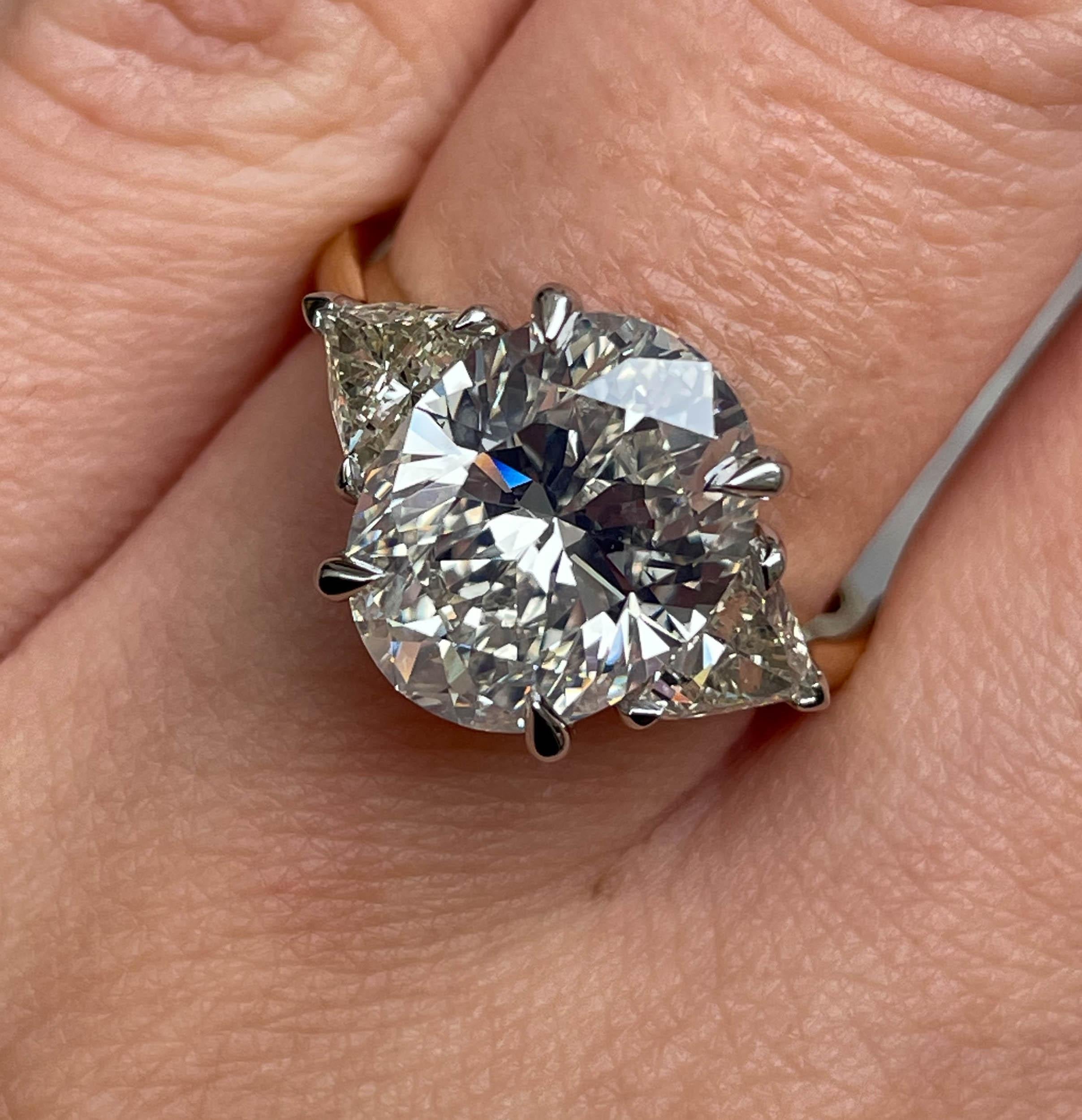A Breathtaking Estate HANDMADE Platinum and 18k Yellow Gold (stamped) Oval Diamond Three-Stone Engagement ring. The Prong Set Oval Shaped Center Diamond is GIA Certified 4.18CT with measurements of 11.56x9.03x5.99mm in L color SI1 clarity (Appears
