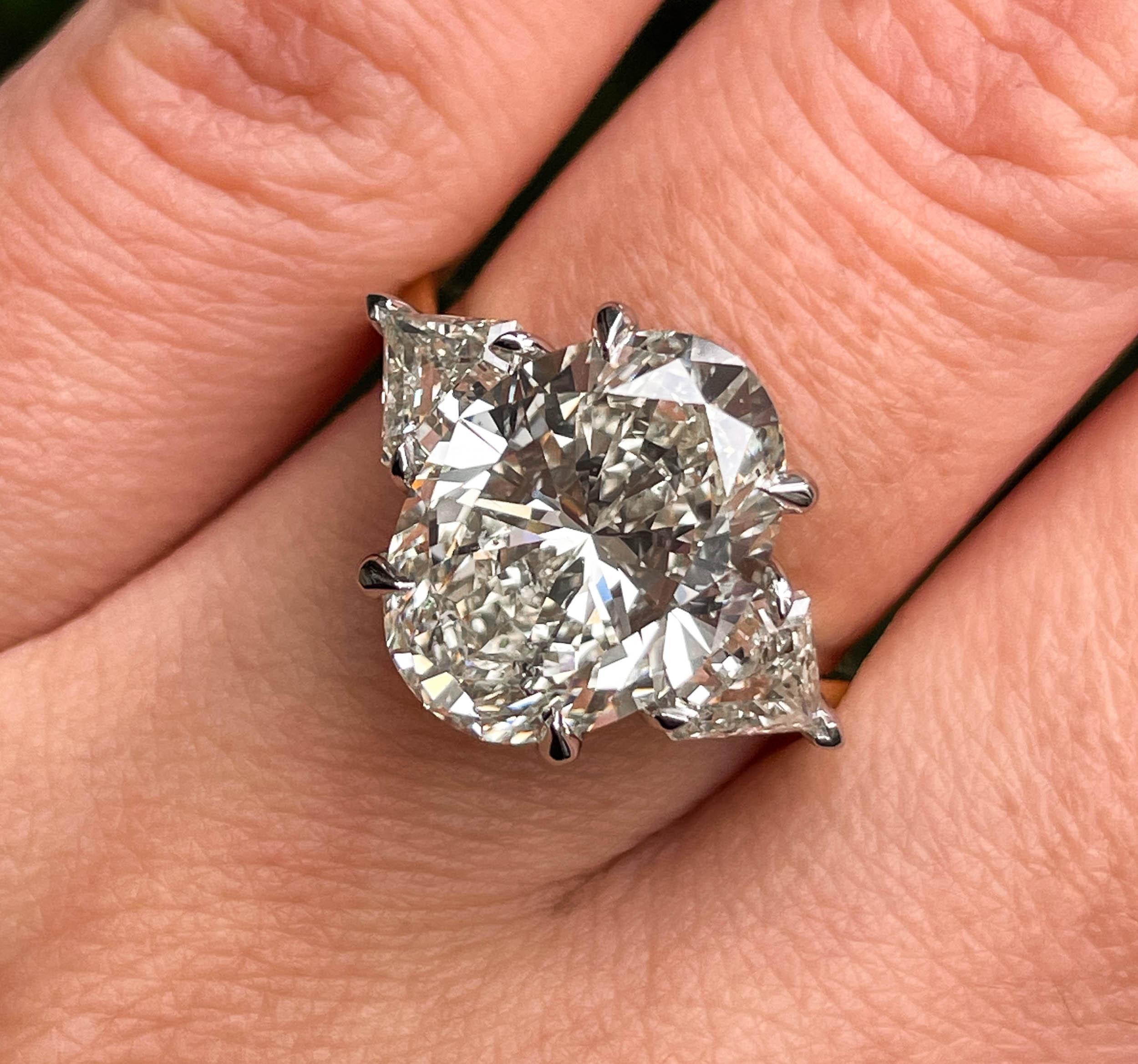 A Breathtaking Estate HANDMADE Platinum and 18k Yellow Gold (stamped) Oval Diamond Three-Stone Engagement ring. The Prong Set Oval Shaped Center Diamond is GIA Certified 5.01CT with measurements of 13.07x9.54x6.16mm in M color SI2 clarity (Appears