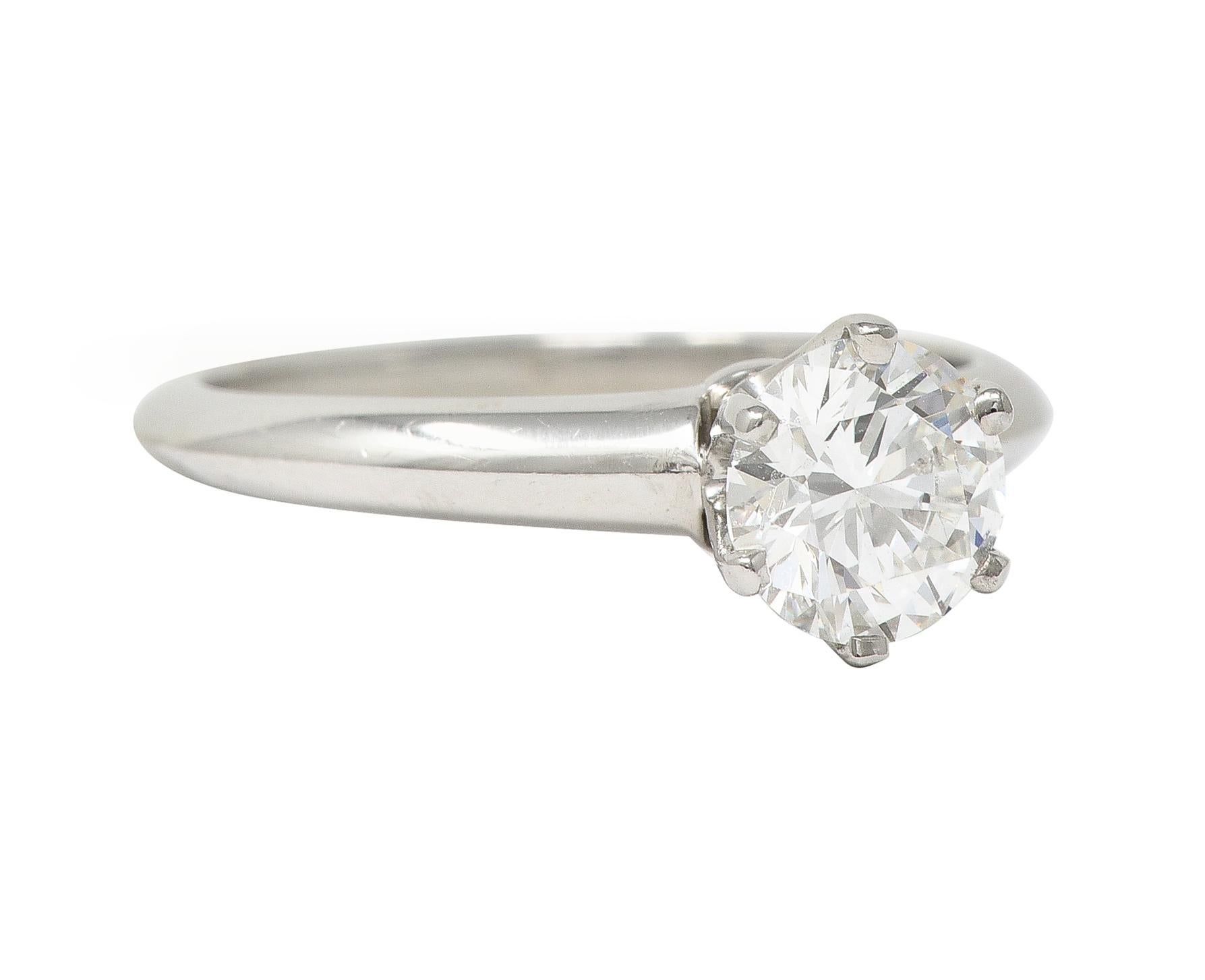 Centering a round brilliant cut diamond weighing 0.90 carat - H color with VS1 clarity
Prong set in a classic six-pronged Tiffany setting 
Completed by knife edge shank with high polish finish
Stamped for platinum
Inscribed with carat