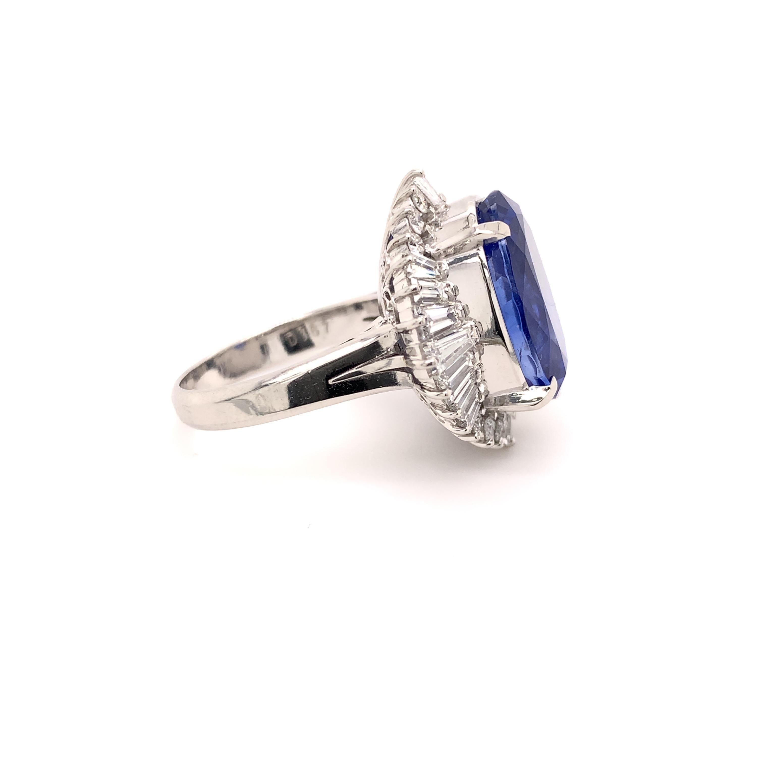 Royal sapphire diamond cocktail ring. Lively violetish-blue, high brilliance, oval faceted, unheated 13.69 carats sapphire mounted in high profile with four prongs, accented with baguette and round brilliant cut diamonds. Handcrafted masterpiece