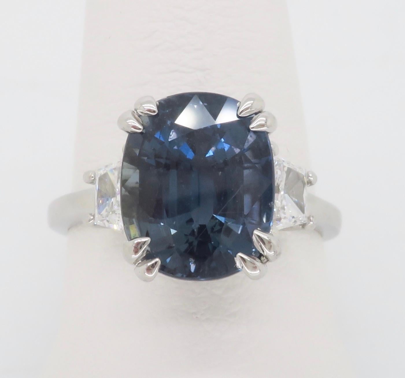 Stunning GIA Certified Unheated, Color Changing Blue Sapphire from Tanzania with strong-vivid saturation, flanked by Trapezoid shaped diamonds. 

Gemstone: Blue Sapphire & Diamond
Sapphire Carat Weight: 7.21CT 
Sapphire Shape: Oval
Certification