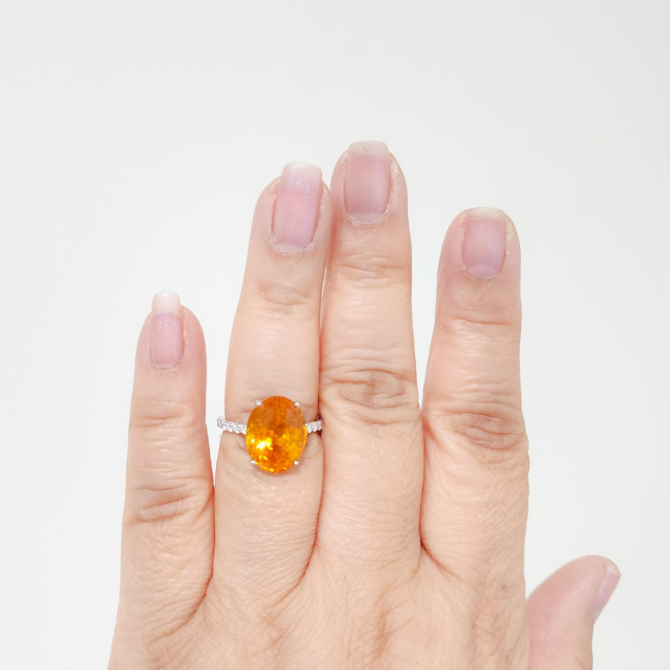 Beautiful bright orange sapphire oval weighing 8.94 ct. with 0.50 ct. good quality white diamond rounds.  Handmade in 18k white gold.  Ring size 7.
GIA certificate included.