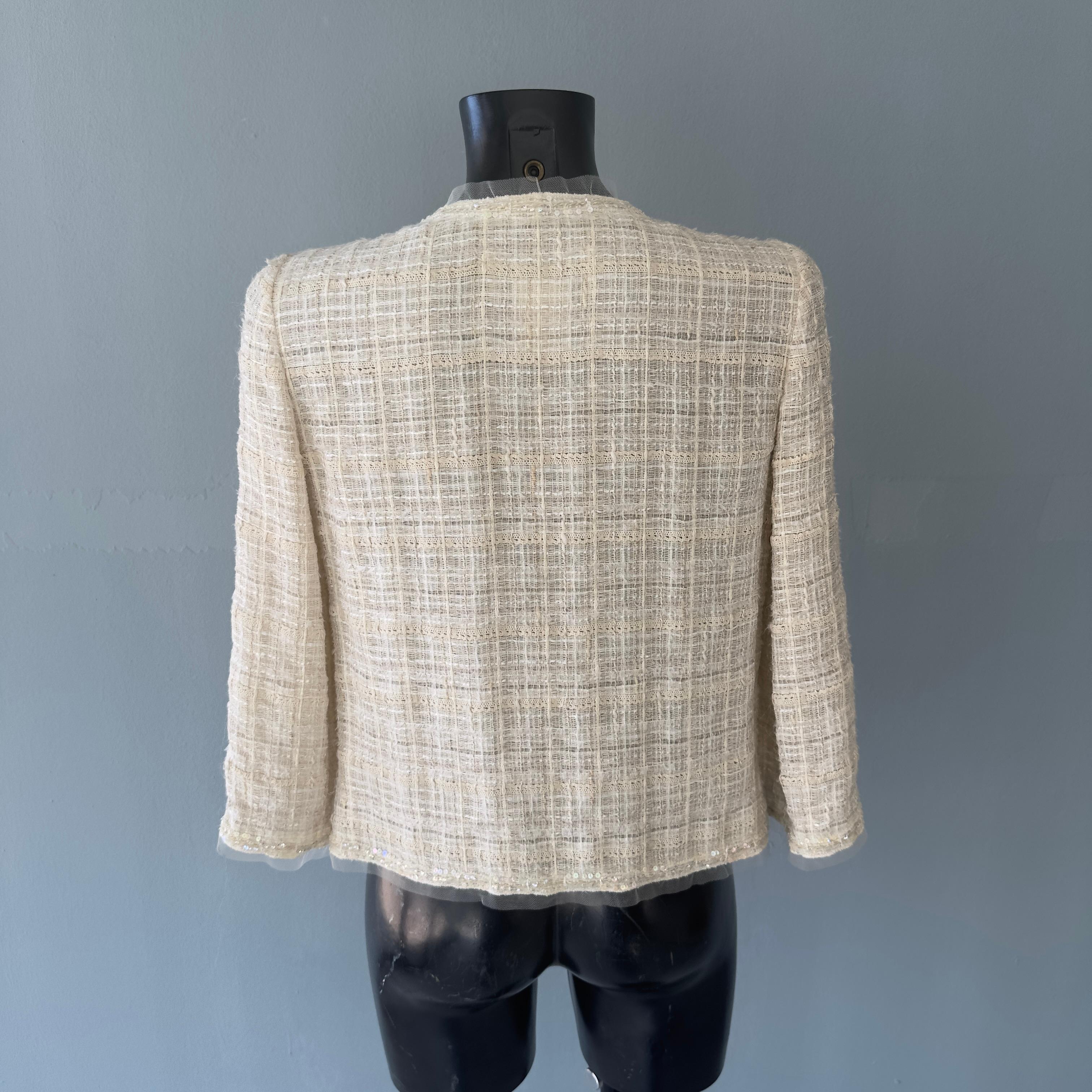 Beige Chanel jacket worked with camellia brooch