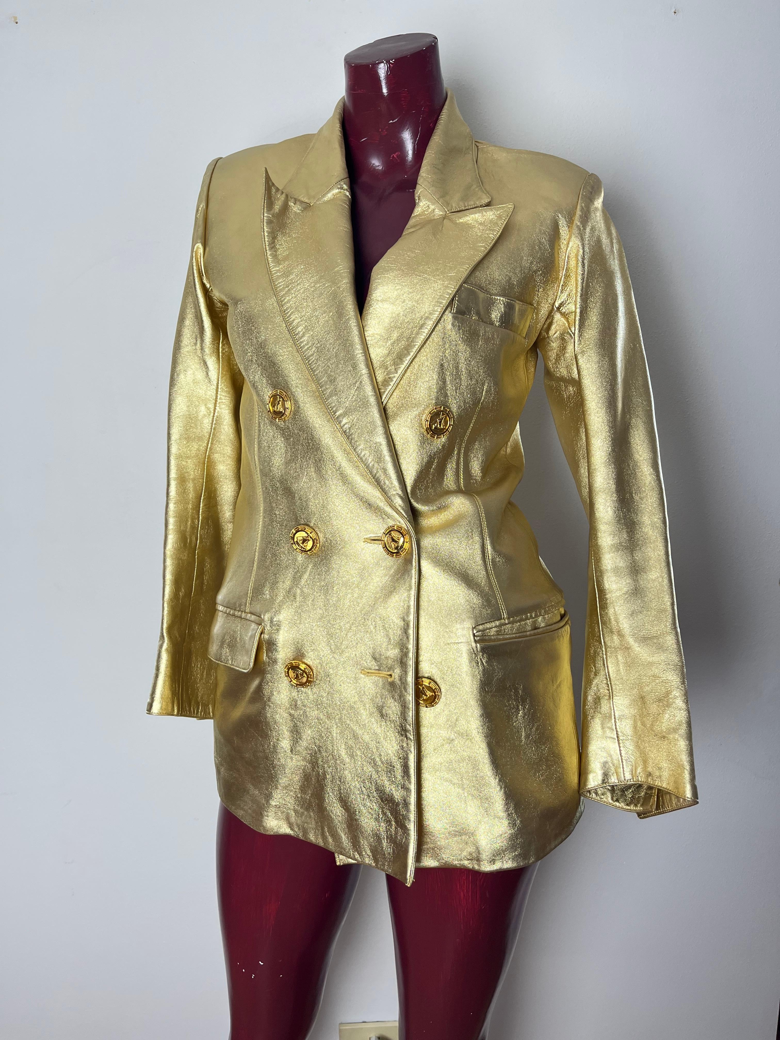 Iconica giacca YSL in pelle di capretto dorata circa 1985.  giacca doppio petto  non avvitata ma dritta .Bottoni con vascello in bronzo dorato Fodera in charmeuse di seta nera. Realizzato da YSL Haute Couture.  Iconico è un termine spesso