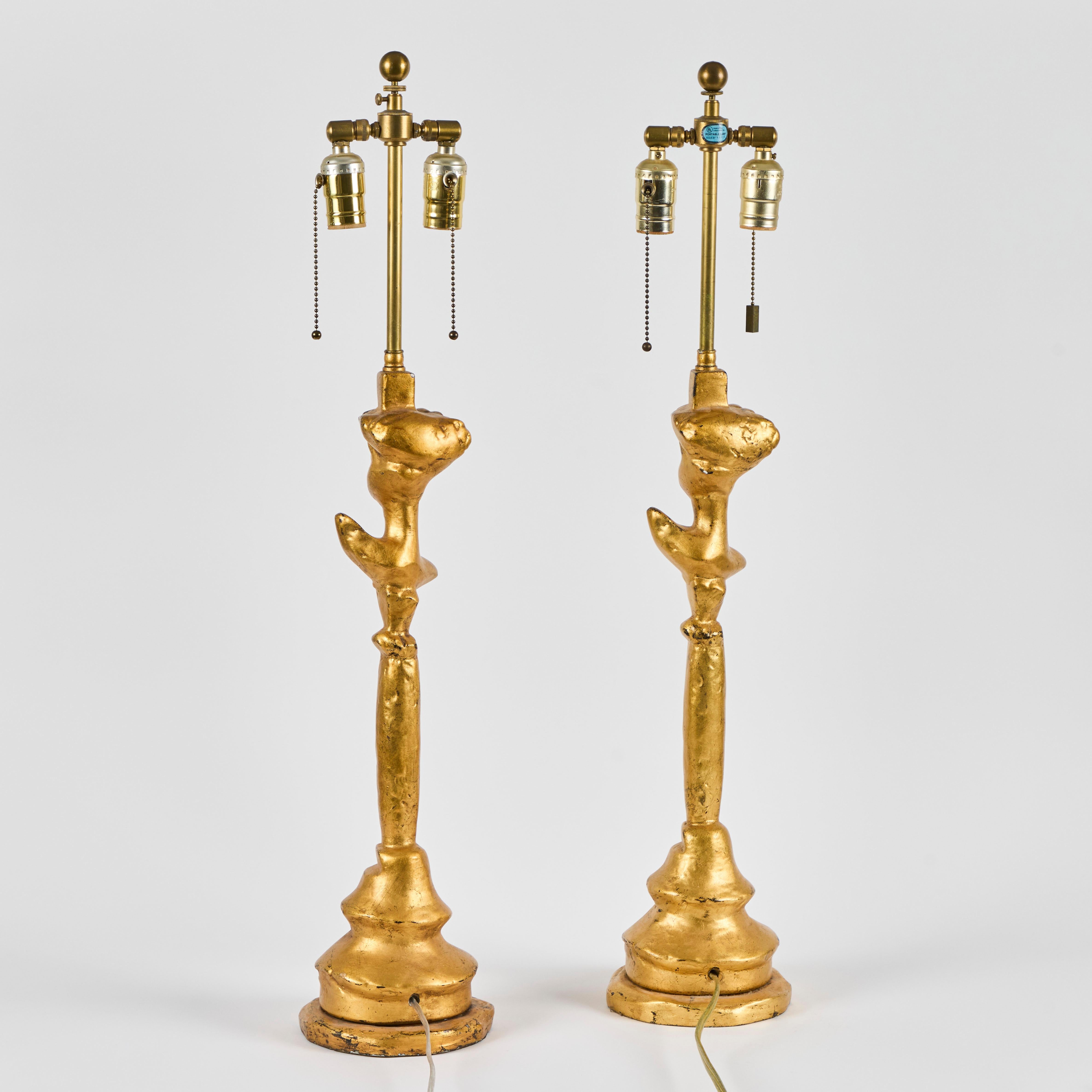 Magnifique paire de lampes tete-a-tete en plâtre doré dans le style de Giacometti.  Les lampes ont été fabriquées par Sirmos dans les années 1970 à 1990 et portent la marque du fabricant Sirmos apposée sur le fond.