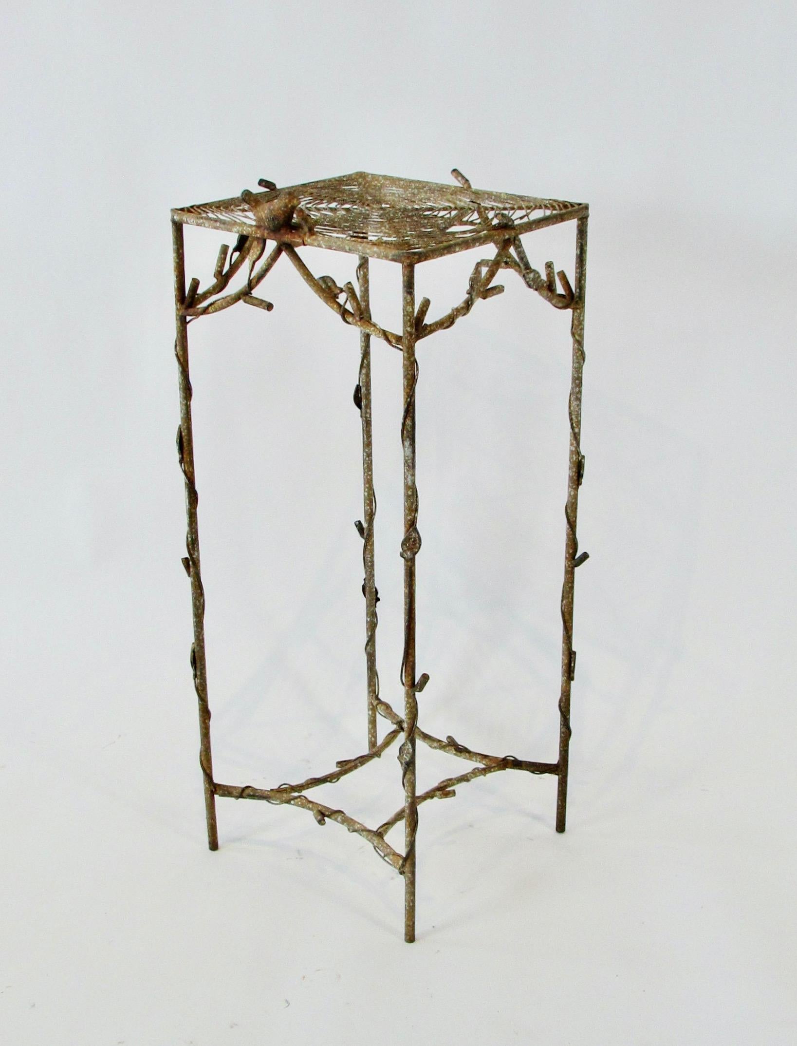 Wrought iron and wire plant stand with bird perched on a spider web top. The legs have a wrapped leaf and vine design similar to pothos ivy. Original paint in weathered patina. Nice for a garden setting. Lightweight table, ships easily.