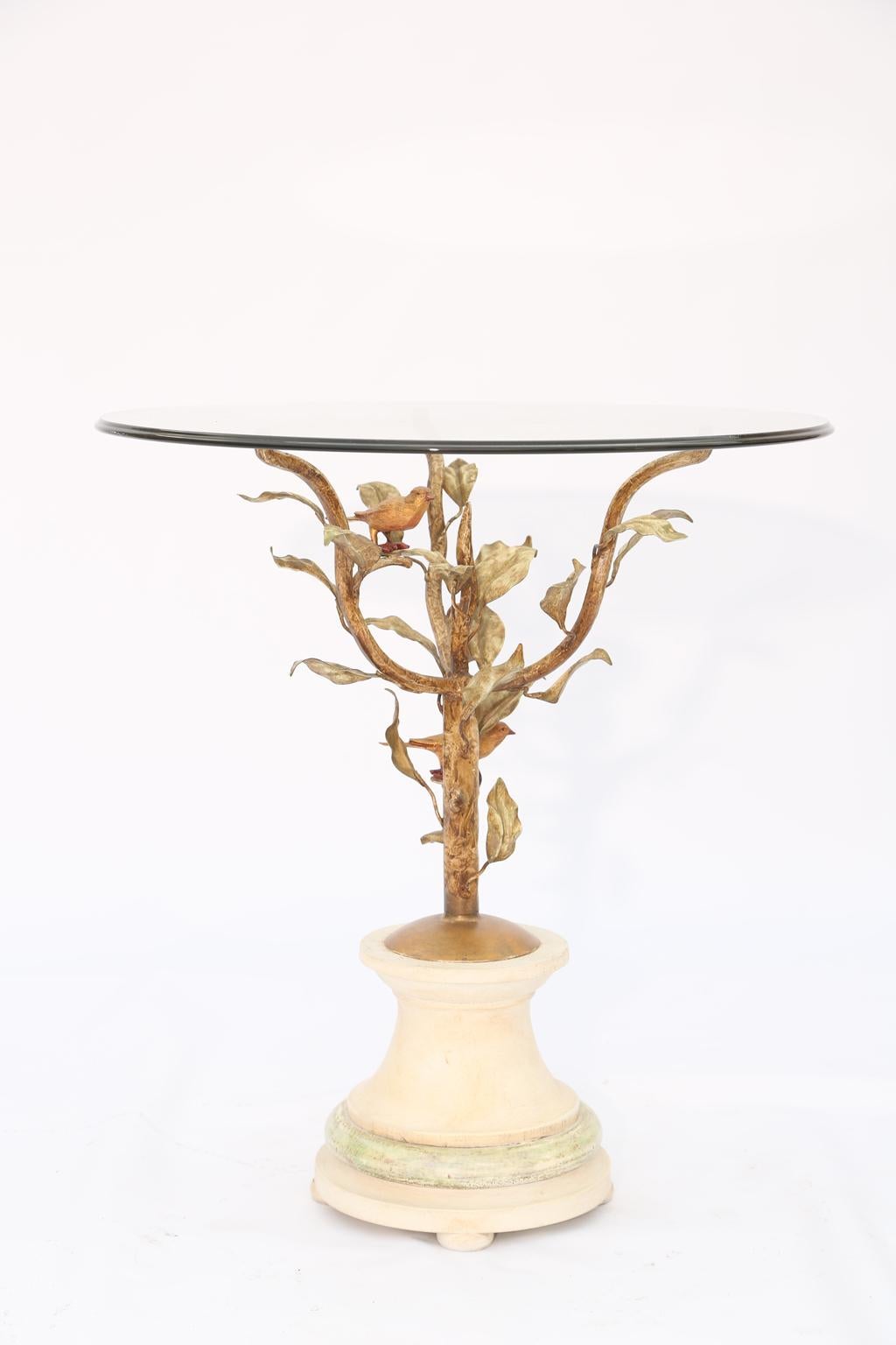 Side or end table, in the manner of Diego Giacometti, having a round top of glass, on frame of gilded iron, its arms formed as leafy branches with birds perched atop, round, painted wooden foot base. 

Stock ID: D1663.