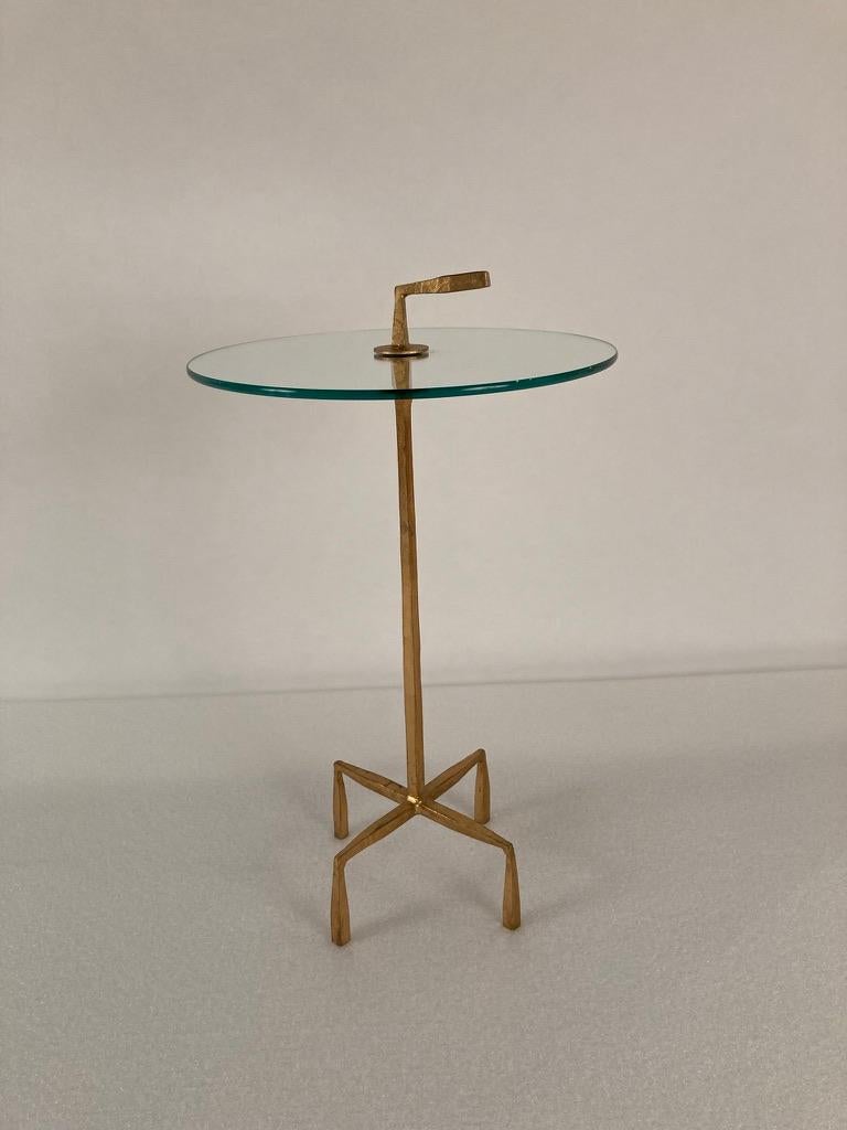 Gilt bronze side or drinks table in the style of Diego Giacometti with a round glass top and a handle for easy placement. This classic modern table has a versatile design, portable elegance.