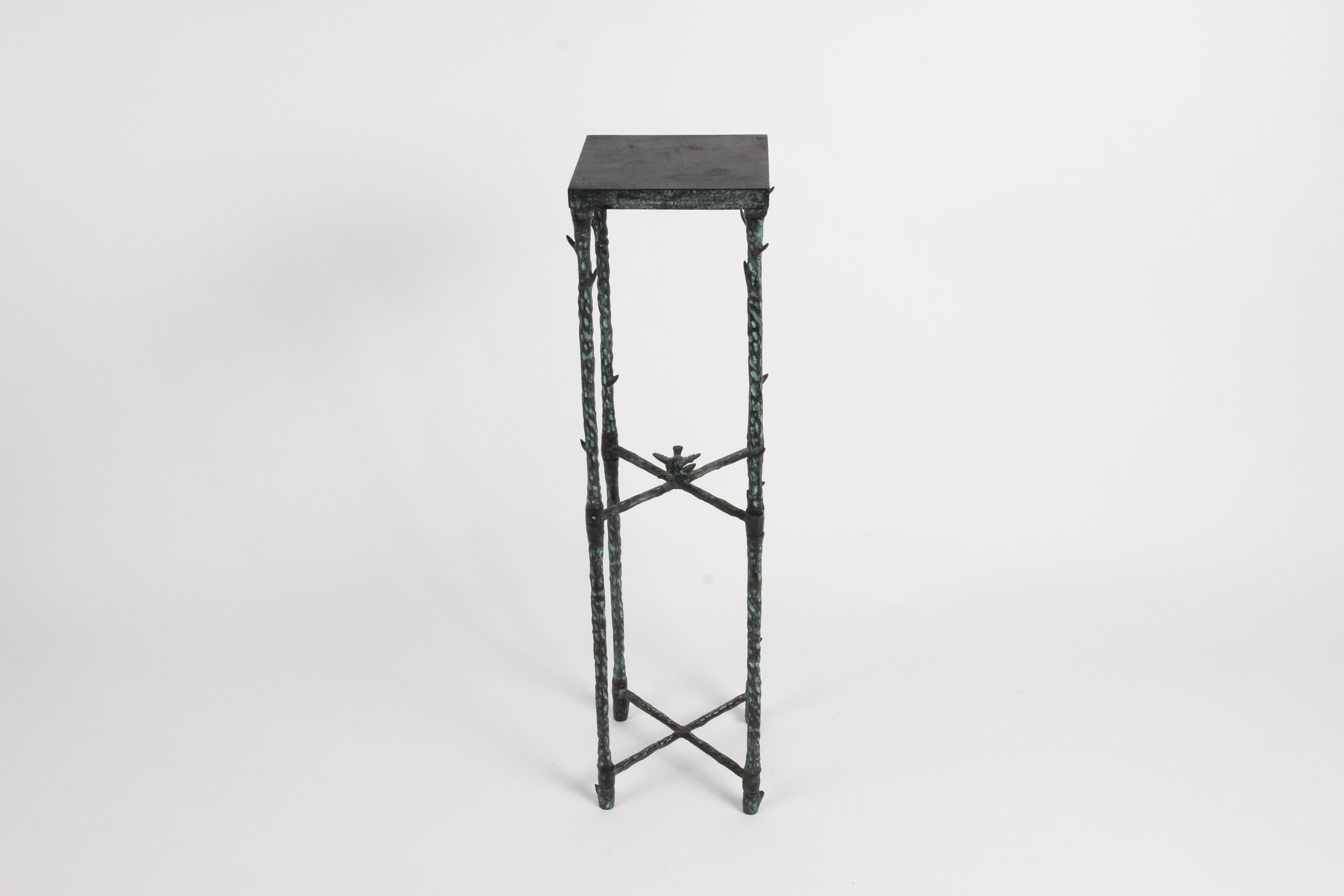 Inspired by the work of Diego Giacometti, this heavy 1980s hammered textured metal display pedestal or plant stand has a faux green applied patina, having thorns on the legs, two cross stretchers and bird motif.  Unsigned. In fine condition. 