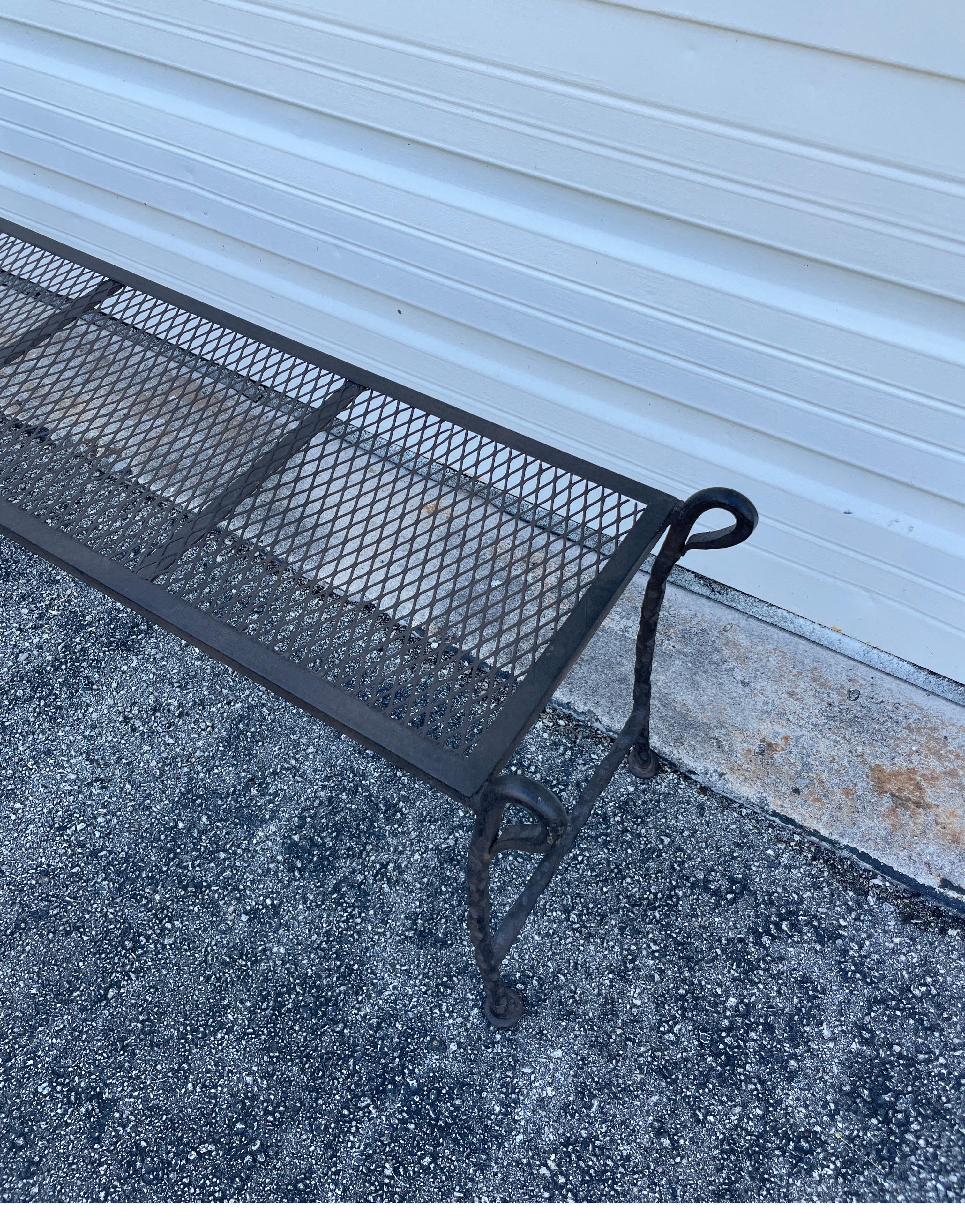 Long iron bench in the style of Giacometti. A very simple stylish piece with a meshed seat and raised turned arms.