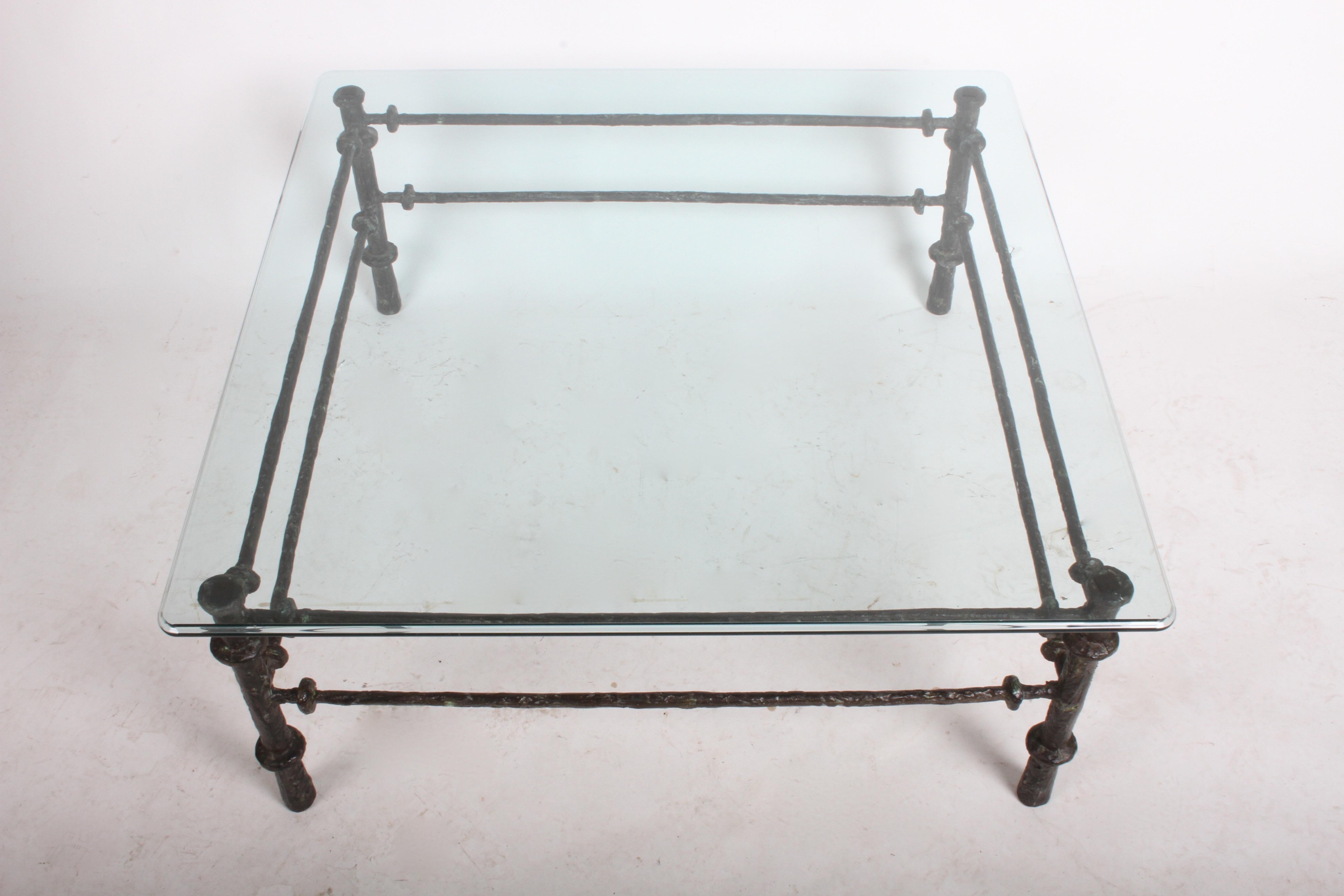 In the manner of Diego Giacometti, patinated faux bronze finish coffee table with thick bevel edge top. In very nice condition, no chips to glass.