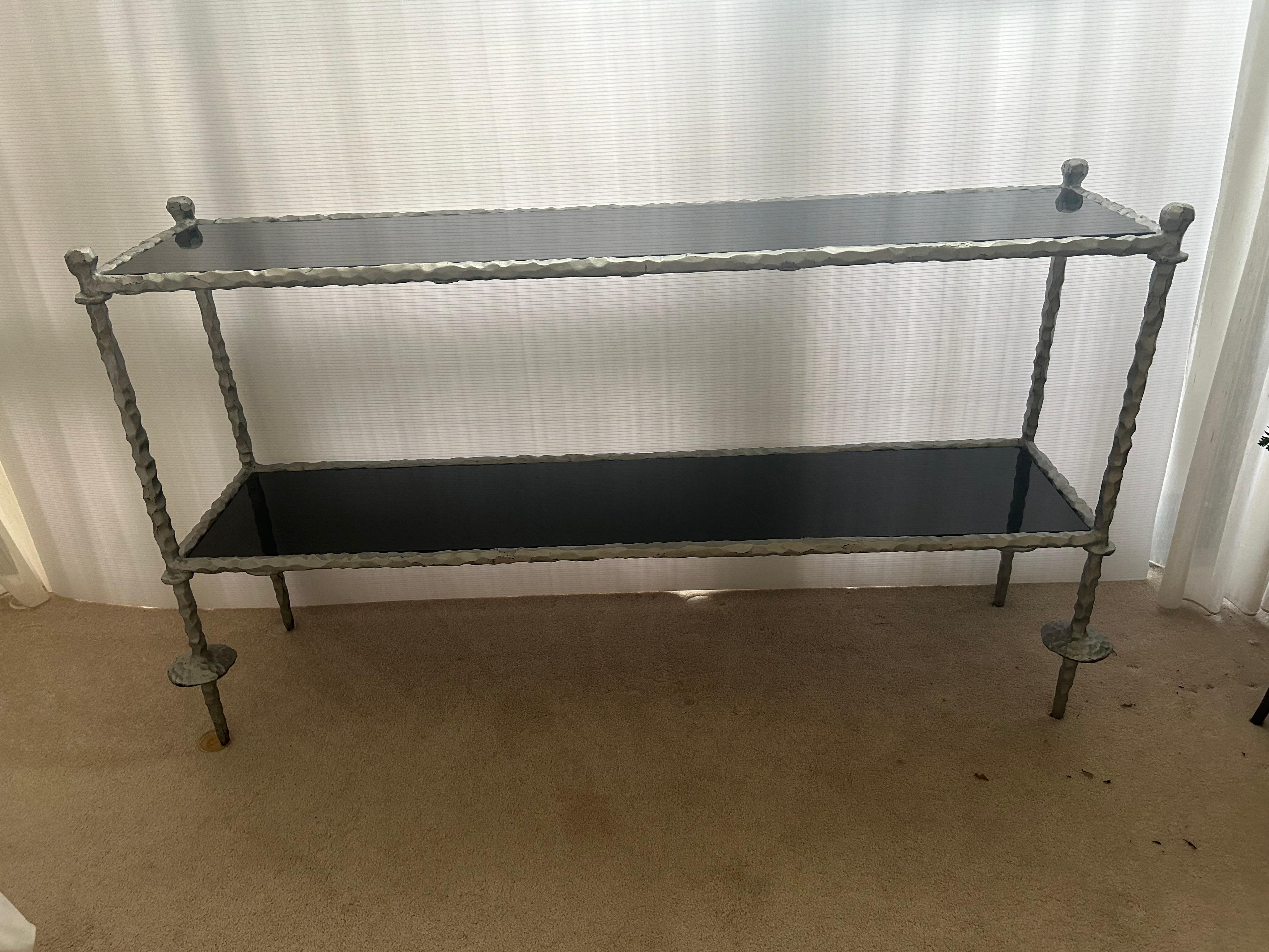 A  wrought iron and black marble two tiered console table.. 34 inches high 60 1/2 half inches wide and 17 1/2 inches deep. in the style of Giacometti. Create reflective, black marble on a very sturdy and heavy wrought iron structure…
