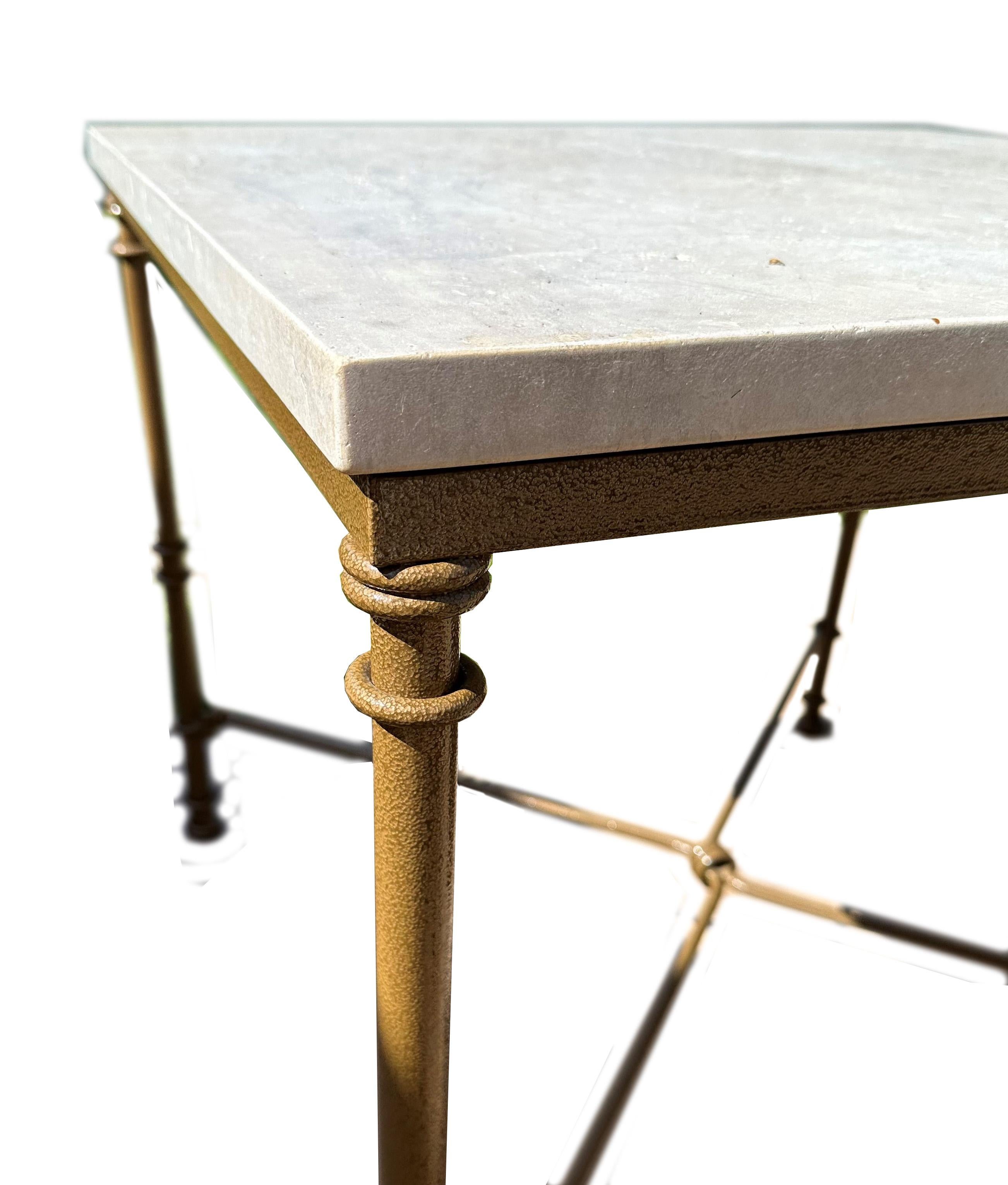 An exquisite Giacometti-style table, a piece that seamlessly integrates artistry with utility. At its heart lies a beautifully honed limestone or travertine top, treated with a bespoke paint and wax finish to not only enhance its natural beauty but