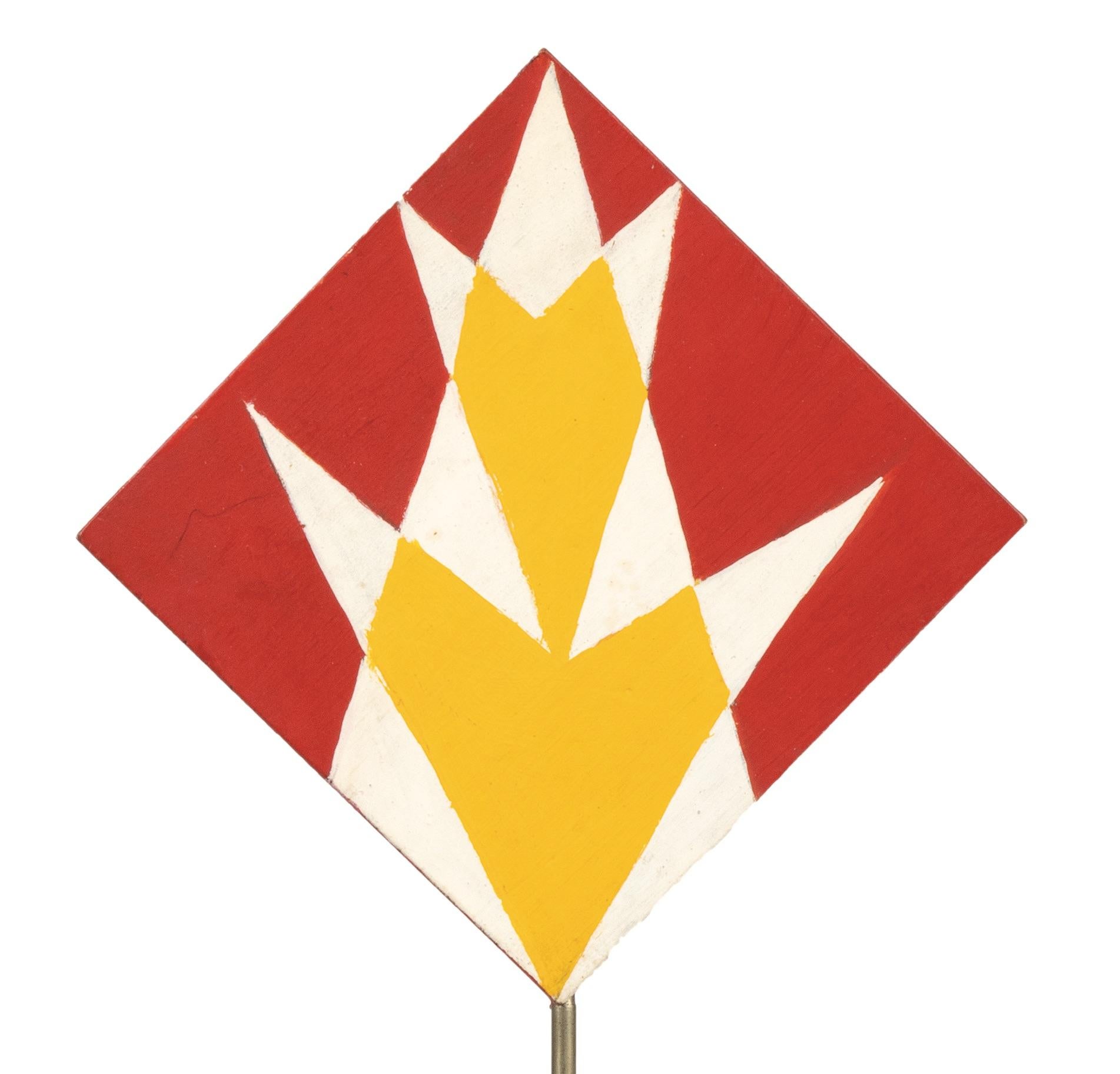 The 'Red and Yellow Triangles'  by Giacomo Balla (1871-1958), geometric pattern with yellow and red triangles down and up (recto and verso), realized in the 1930s.

Tempera on wood, aluminium structure and plastic base, 22 x 10,7 cm (23,5 x 10,7 cm