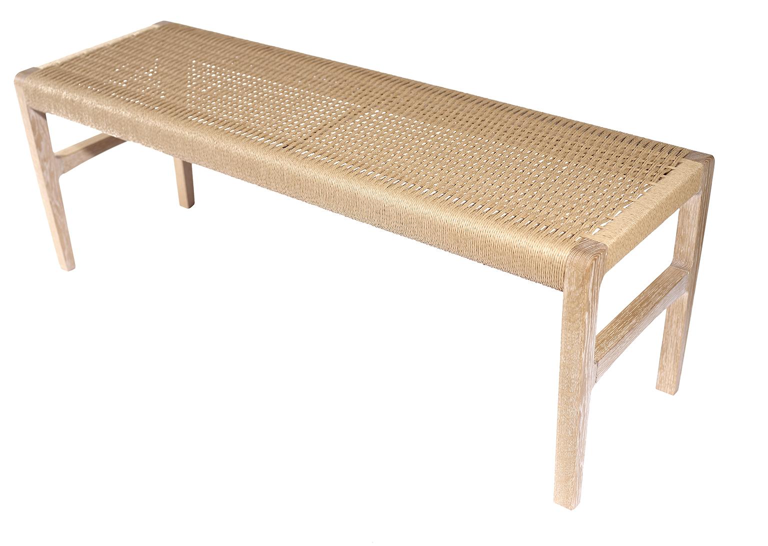 A bench with subtle curves (shown in cerused white oak) with a woven Danish cord seat, perfect for use in the bedroom, hallway, living space or kitchen. Measures 59”.
