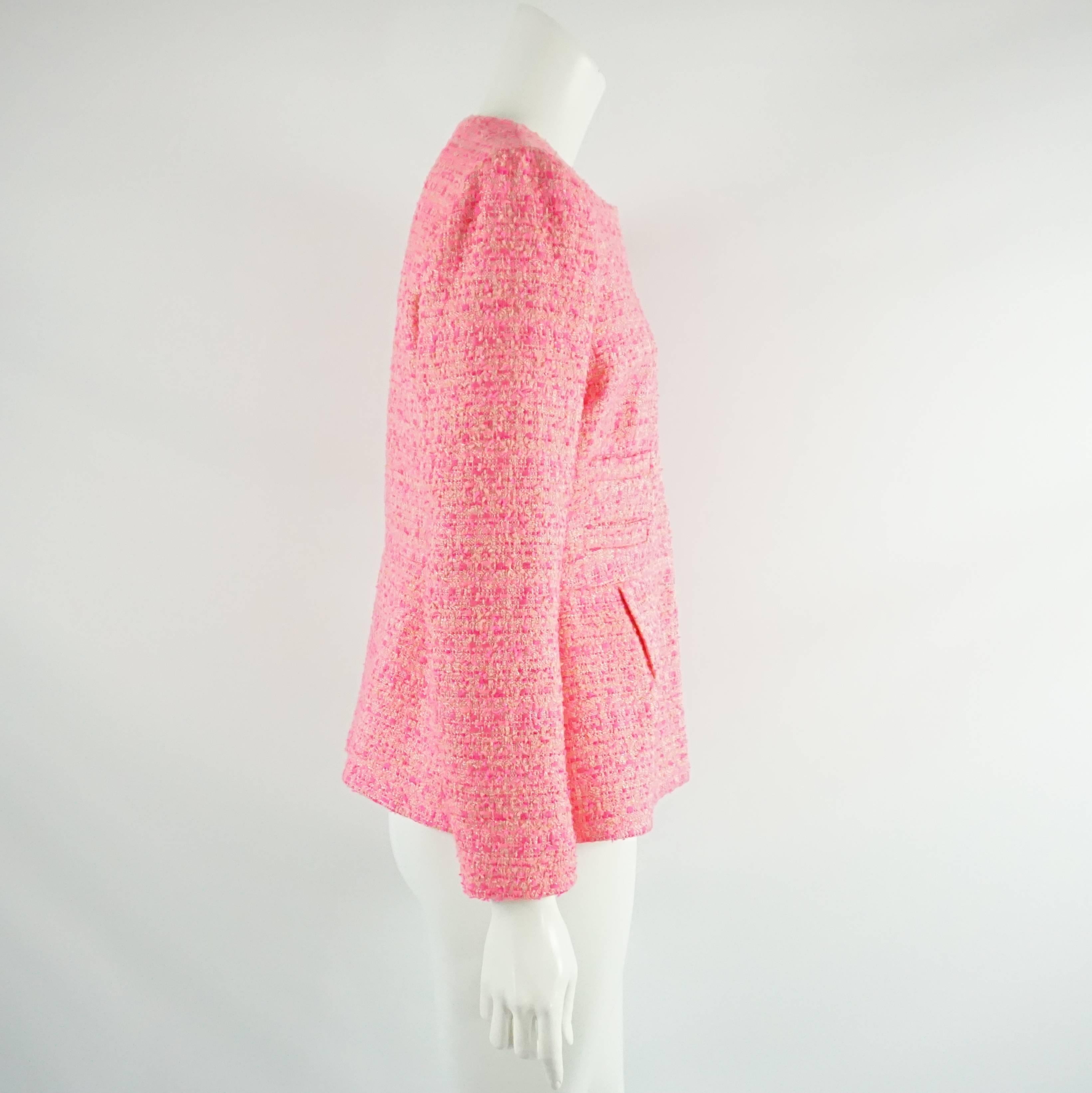 This Giambattista Valli bright pink jacket has differing hues of peach and pink and is made of a synthetic blend. The jacket has a round neck, slight peplum, light shoulder pads, 4 faux pockets in the front, and snap buttons. It is in excellent