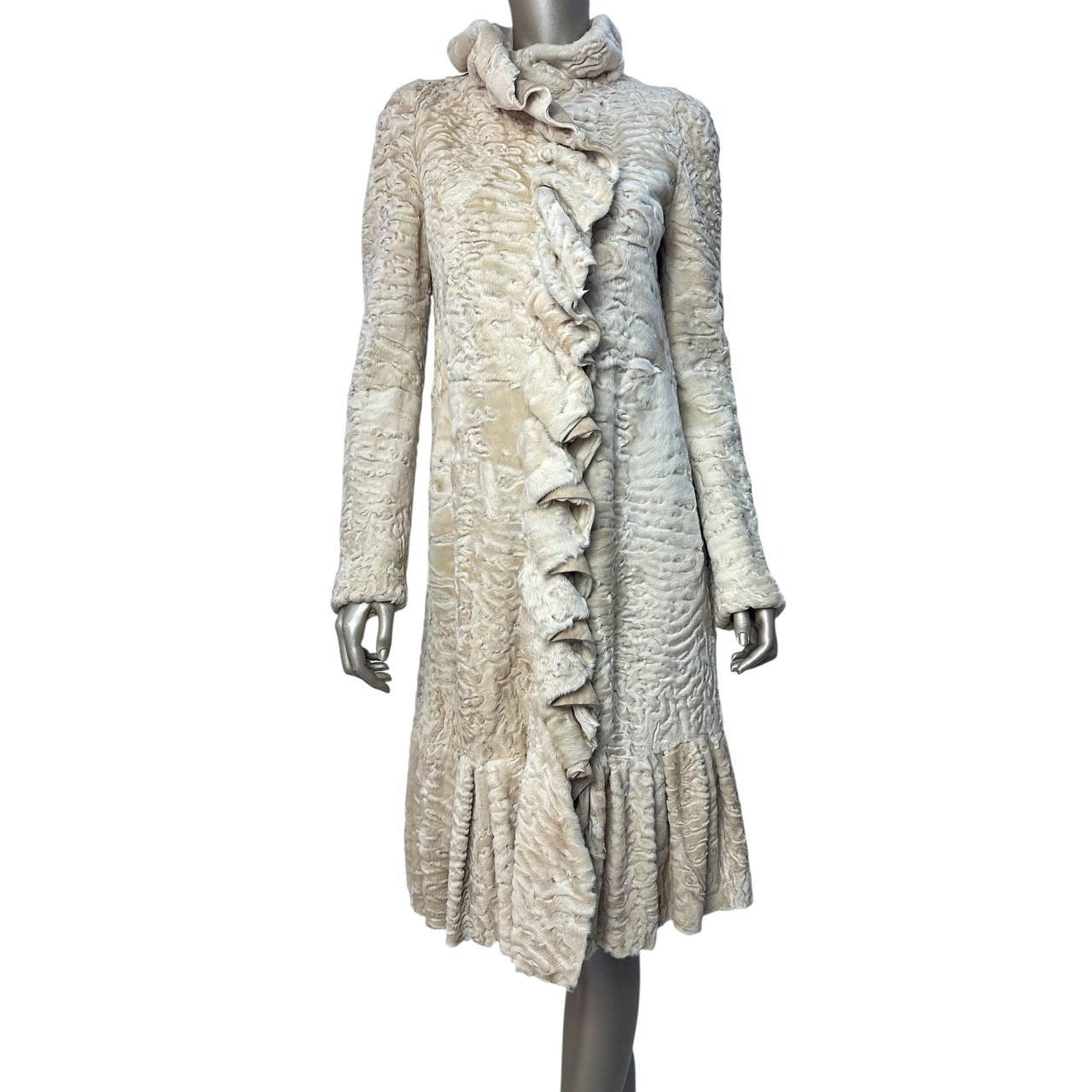 Concediti un lusso senza tempo con questa pelliccia autentica di Giambattista Valli, realizzata in vero Karakul (agnello persiano) in un'elegante tonalità beige-crema. L'inconfondibile volant sul davanti e sull'orlo riflette la rinomata estetica