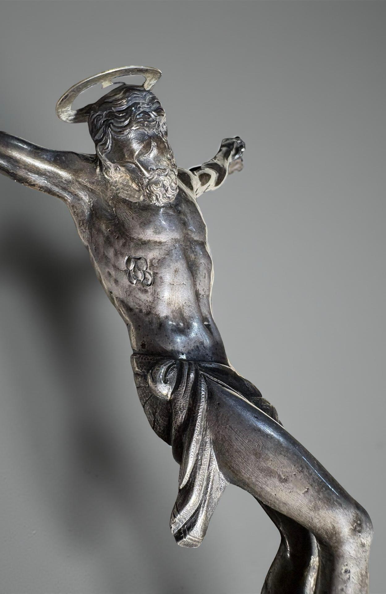 Corpus Christi in argento massiccio, bottega orafa toscana, prima metà del 17 secolo. 
La figura del Cristo, realizzata a fusione a cera persa e sapientemente rifinita a cesello, appartiene a quella produzione iconografica tardo manierista e proto