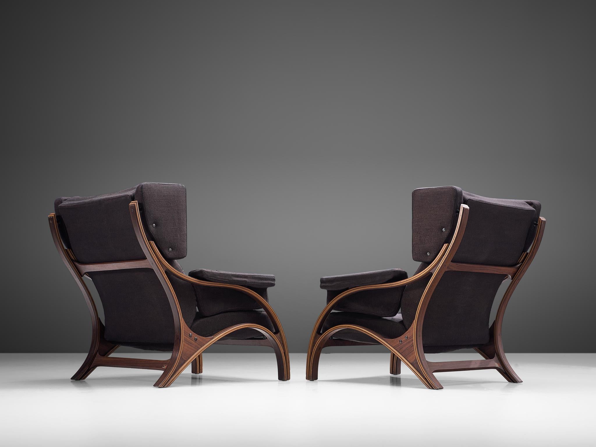 Giampiero Vitelli, pair of lounge chairs to be reupholstered, rosewood and fabric, Italy, 1960s.

Set of Italian wingback chairs that feature curves and gracious forms. The most interesting feature is the rosewood frame with its fluid lines. The