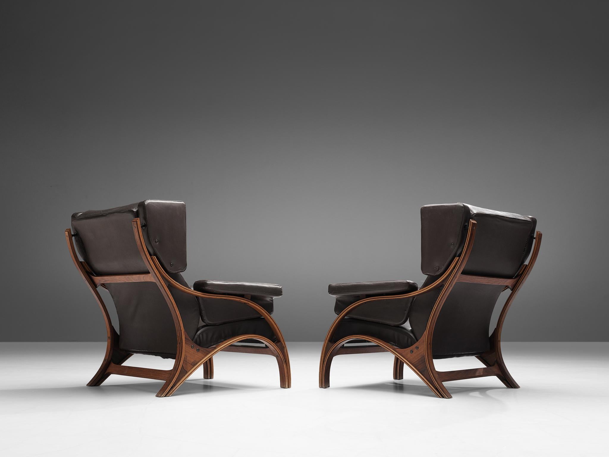 Giampiero Vitelli, pair of lounge chairs, plywood, wood, dark brown leather, Italy, 1960s

Pair of Italian wingback chairs that features curves and gracious forms by Giampiero Vitelli. The most interesting feature is the wooden frame with its fluid