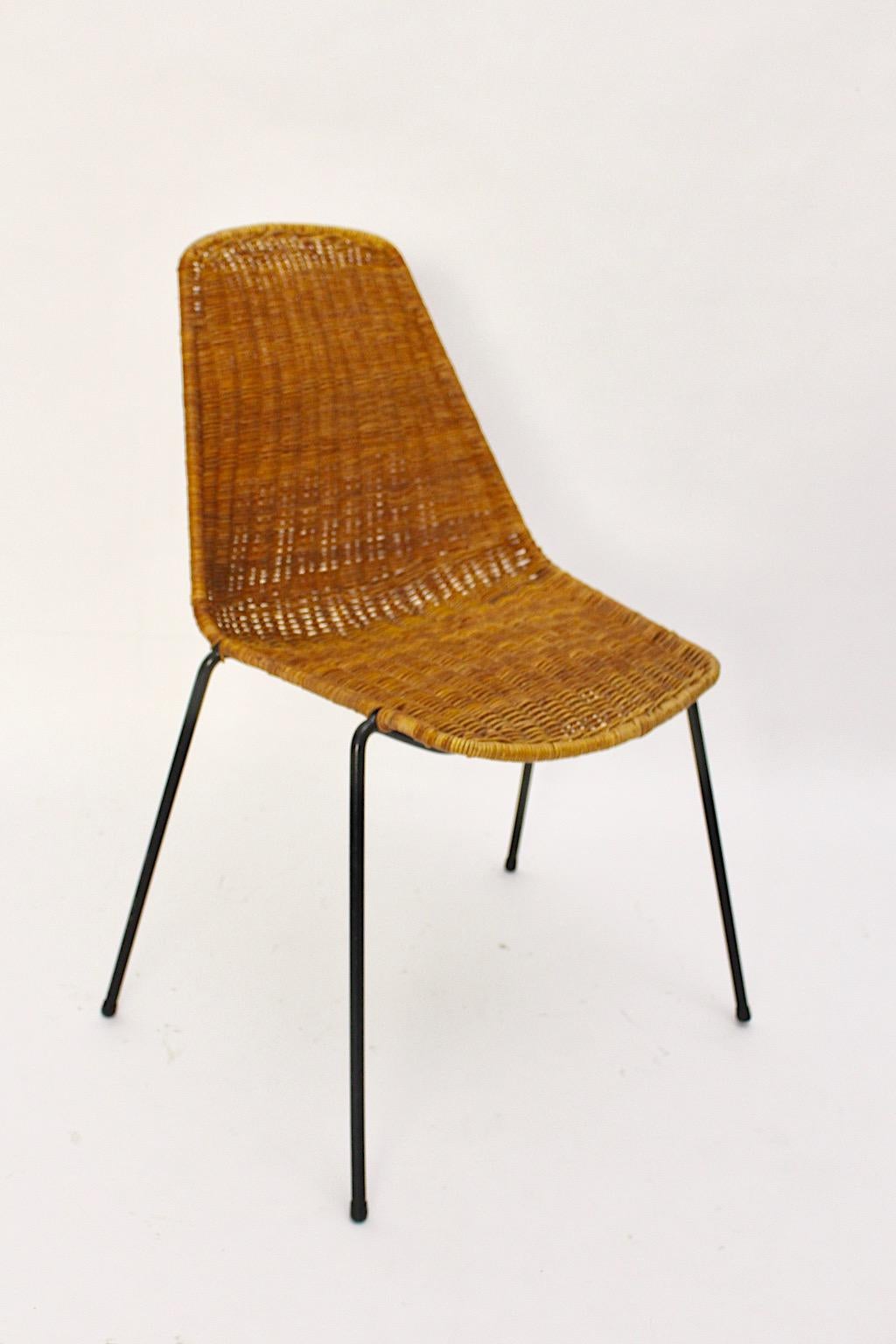 A Gian Franco Legler vintage rattan metal Mid-Century Modern chair or dining chair, which was designed 1951 Switzerland for the restaurant basket.
The rattan chair attributes a black lacquered metal frame and a handwoven rattan seat shell. The