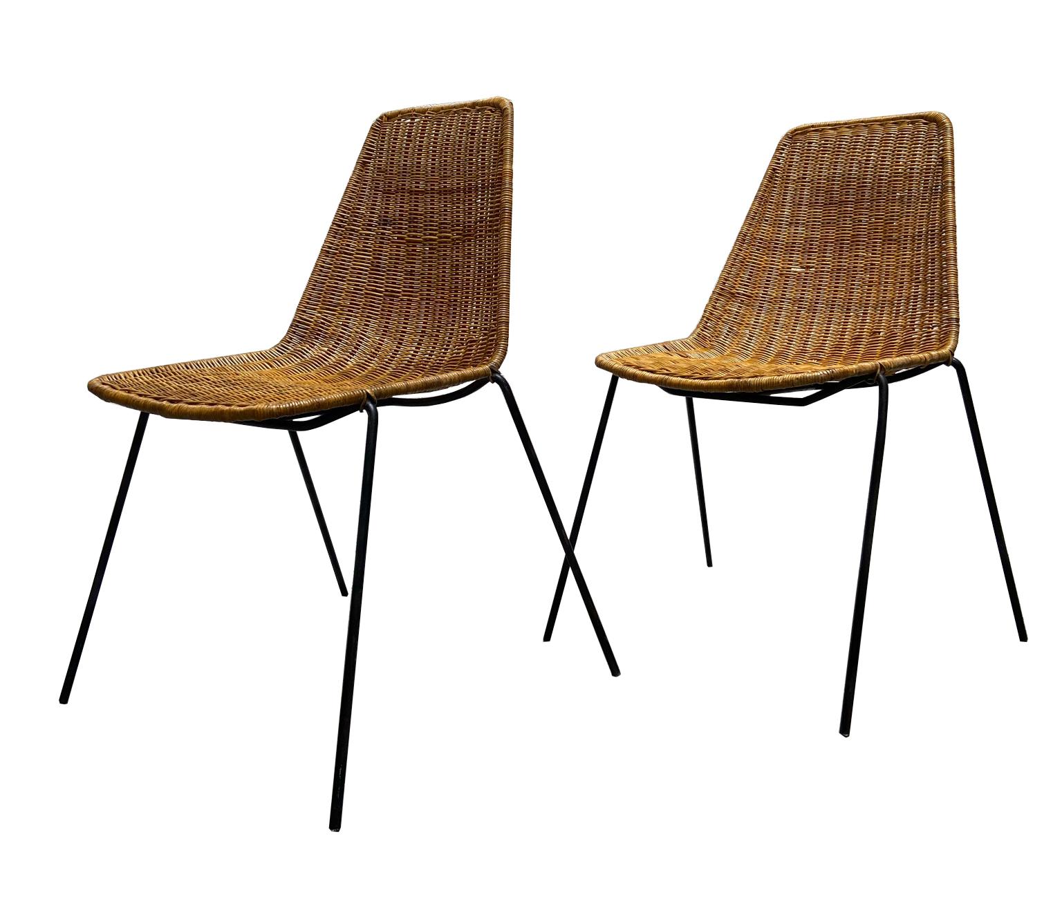 Set of two Mid-Century Modern rattan chairs designed by Swiss designer Gian Franco Legler 1951. 
The rattan chairs have a black enameled metal frame. 
The seat shell was made of wicker. 
Very good condition.