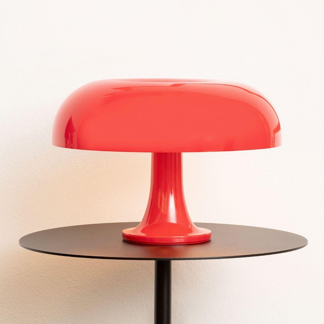 Lampe de table 'Nessino' de Giancarlo Mattioli en rouge pour Artemide.

Cette lampe est devenue une icône du design, avec sa forme de champignon et ses teintes orange ou blanches vives. Lancé en 1967, le Nessino était une merveille de moulage par