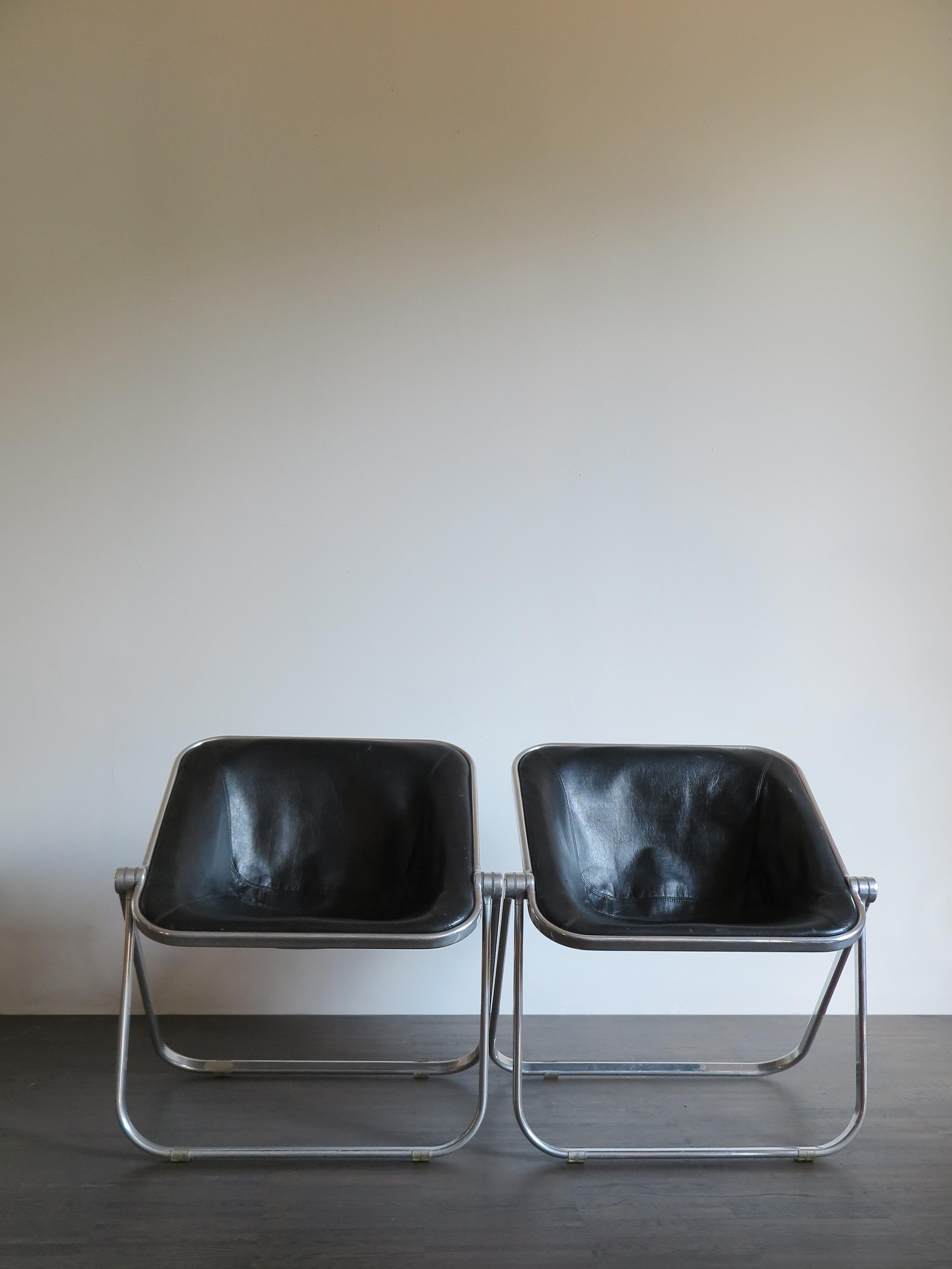 ‘Plona’ famous leather italian foldable chairs / armchairs designed by Giancarlo Piretti and produced by Anonima Castelli from 1969, the armchairs consist of an aluminium frame and upholstered in black leather shell, the aluminum shows some songs