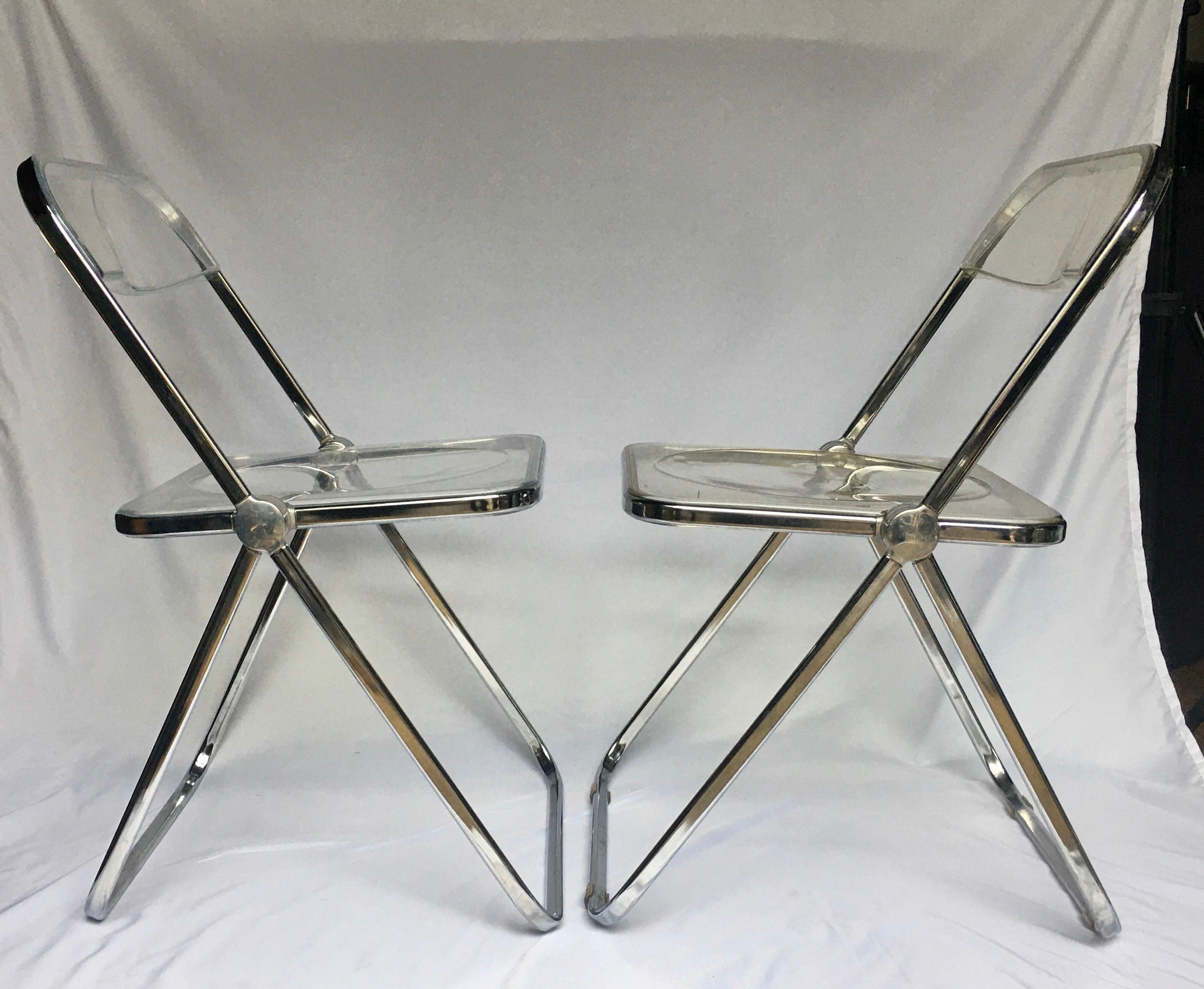 Original signed pair of Mid-Century Modern slim 'Plia' folding chairs by Giancarlo Piretti. These Italian designed dining chairs feature chrome-plated steel-tube frames with clear Lucite acrylic seats and backs. The unique folding mechanisms make it