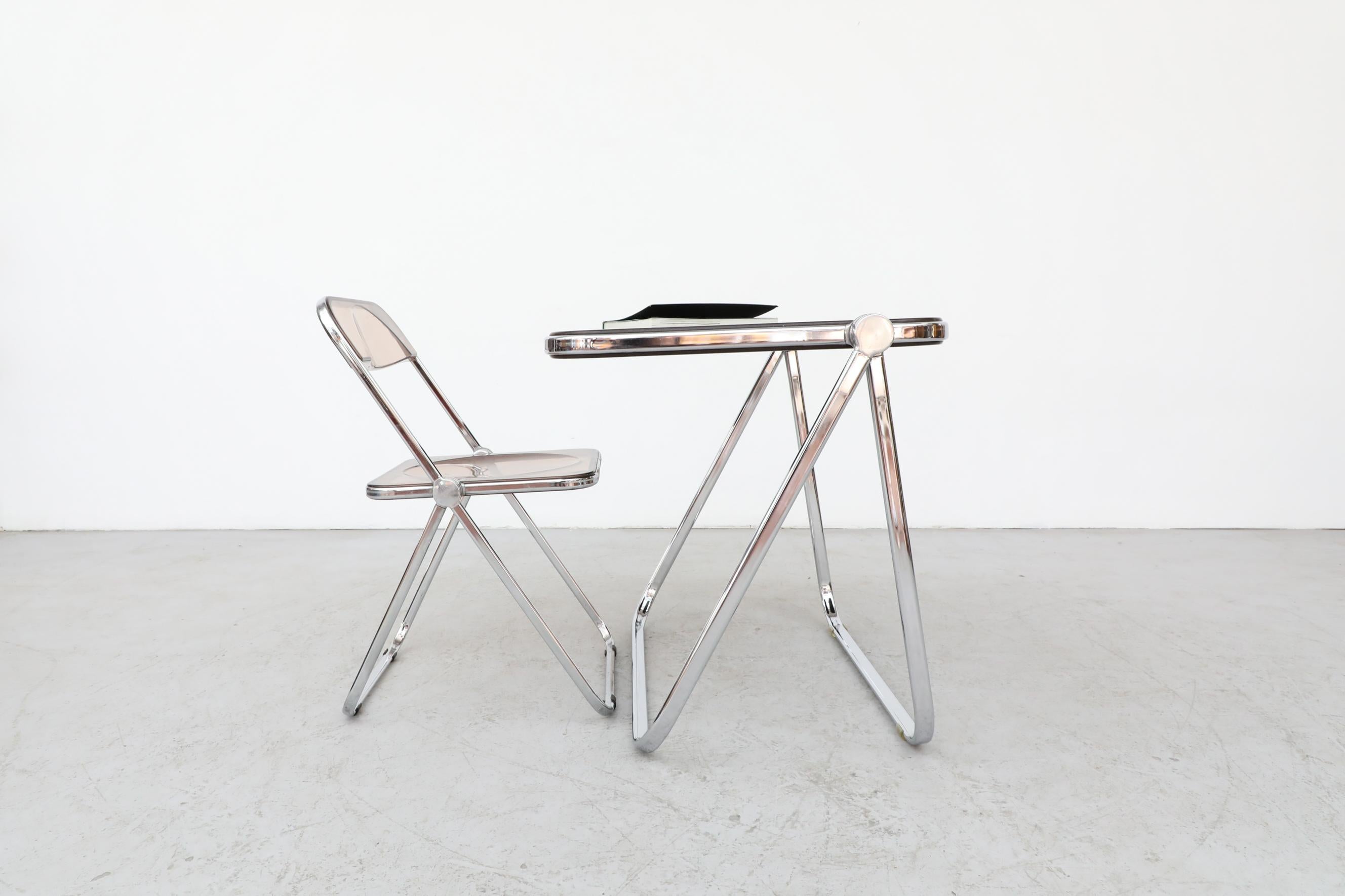 Platone folding table, designed by Giancarlo Piretti for Castelli,1970. Chrome plated tubular steel frame with die-cast aluminium alloy joints and molded polyurethane top. In good original condition with visible wear including visible scratching to
