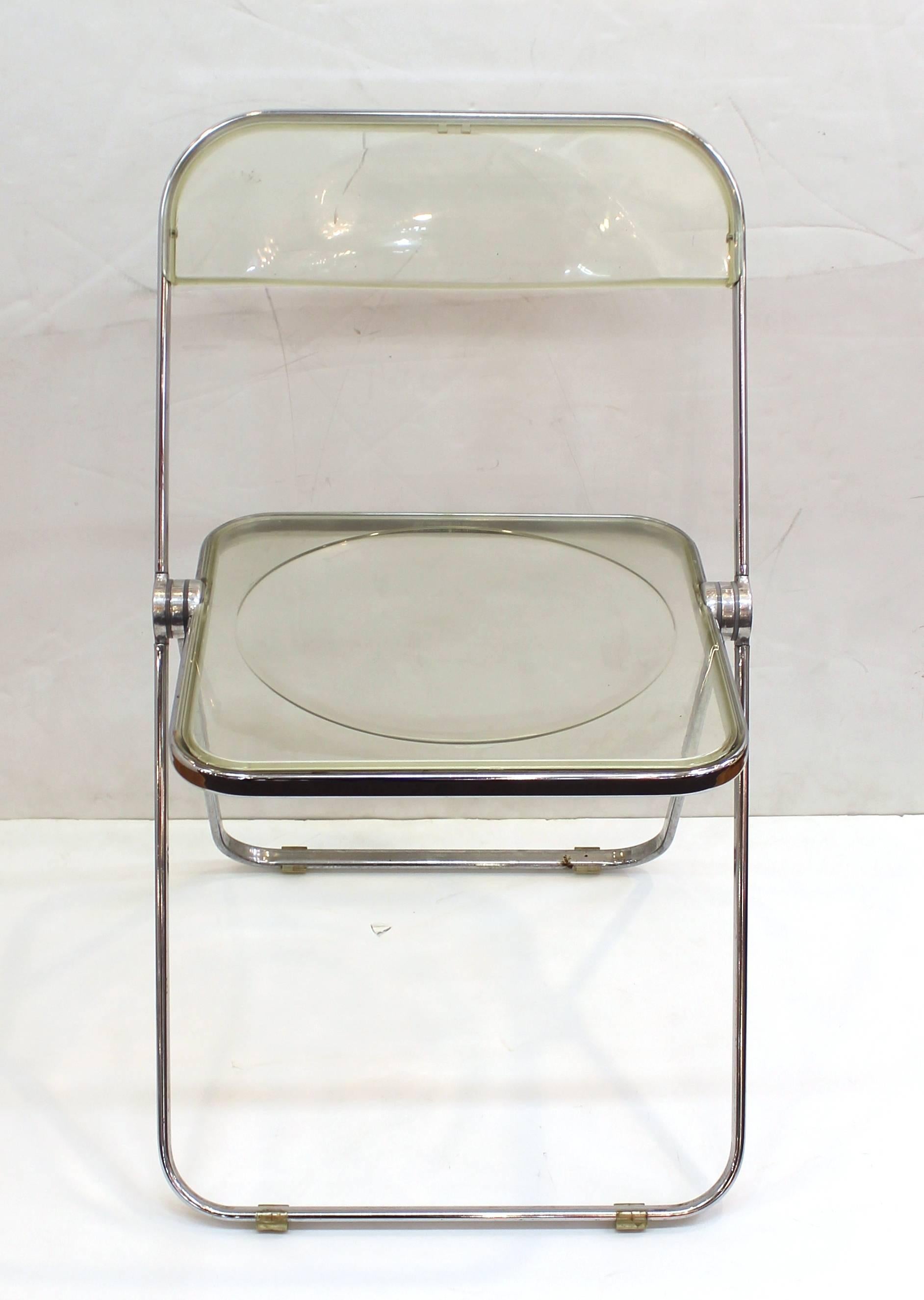 Giancarlo Piretti for Castelli folding 'Pila' chairs in light amber Lucite. The set of five are crafted with modernist frames of chrome over steel. Some of the chairs include the original label. Wear appropriate to age and use such as tarnish to the