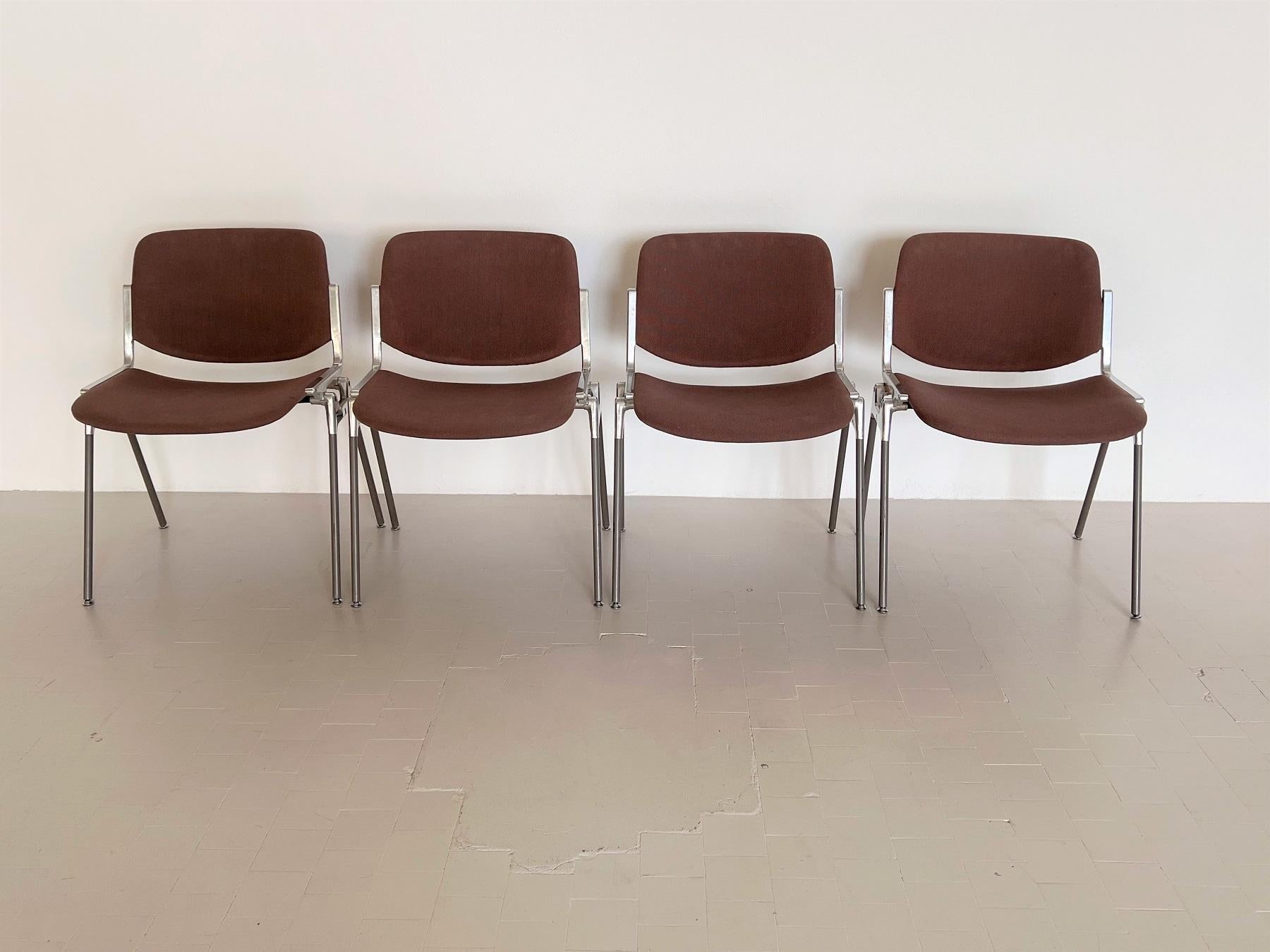 A set of four Giancarlo Piretti DSC 106 chairs in original brown upholstery.
Form and function joined in the Design of these well known stacking chairs by Giancarlo Piretti for Anonima Castelli. 
They are used as dining chairs as well as office