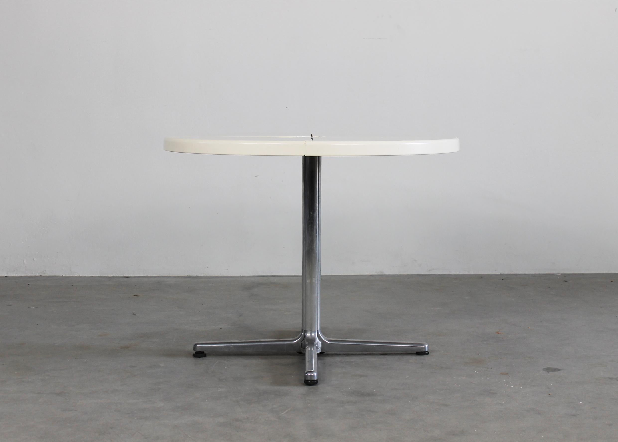 Round Plano folding table with die-cast aluminum base with wheels and table top in white polyurethane.
Designed by Giancarlo Piretti and produced by Anonima Castelli in the 1970s.

(With the manufacturer's label) 

Giancarlo Piretti was born in