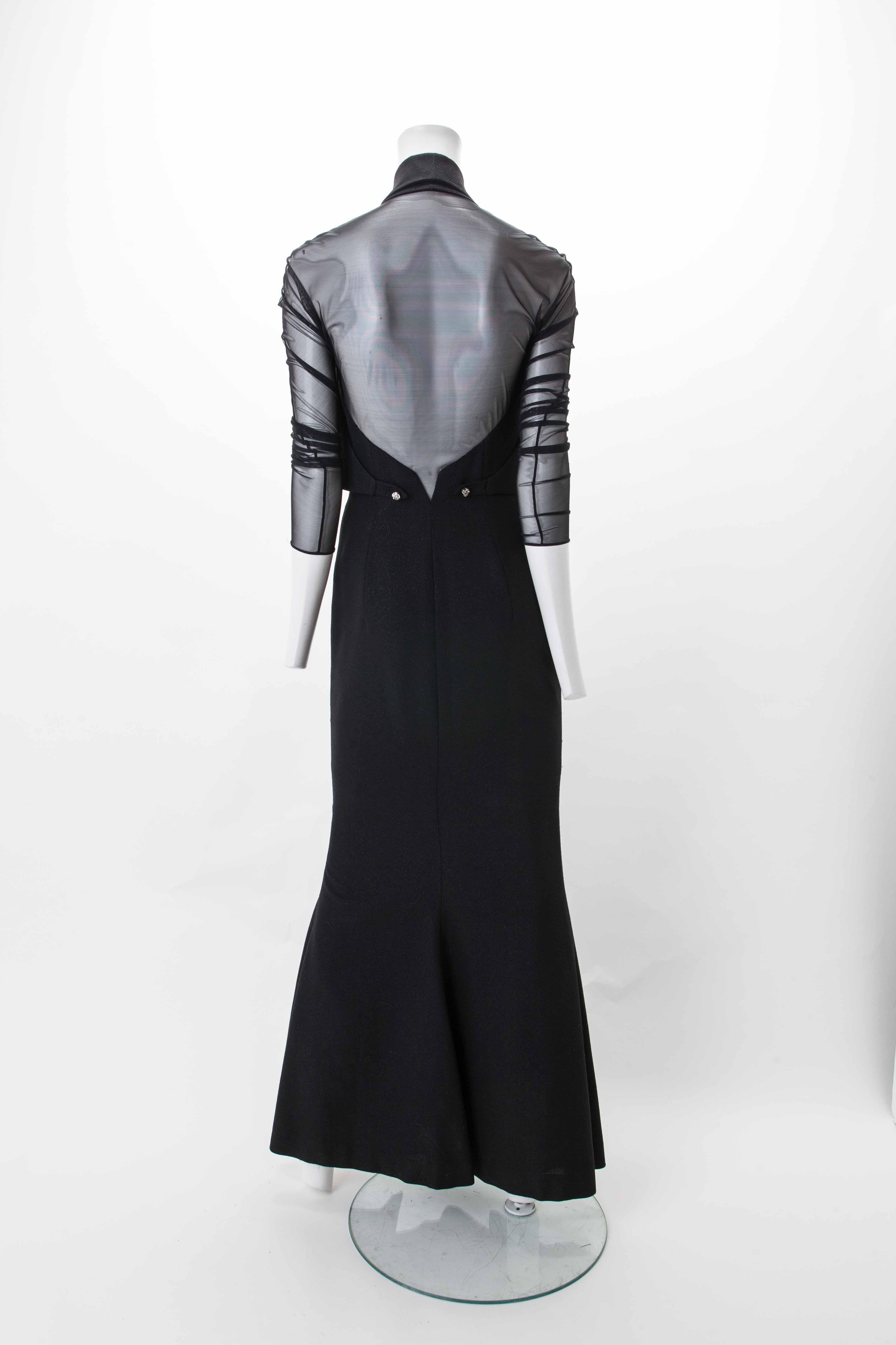 Gianfranco Ferré black gown with sheer sleeves, ca. 1970
Long black wool dress with subtle shimmer featuring waistcoat-style bodice with sheer sleeves. Mermaid skirt features diagonal zipper closure from waist area down to below the knee. Sheer back