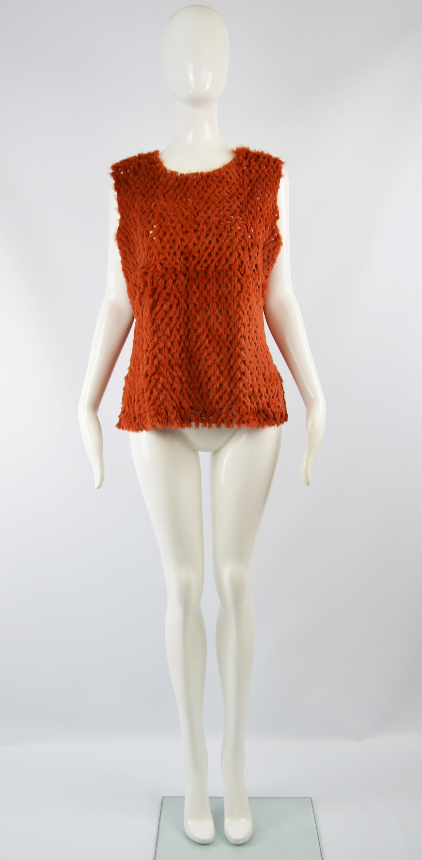 A fabulous vintage women's tank top / sleeveless sweater by luxury Italian fashion designer, Gianfranco Ferre. In a burnt orange rabbit / coney fur with intricate cut outs and a jersey back. Perfect for layering in the day or dressing up in the