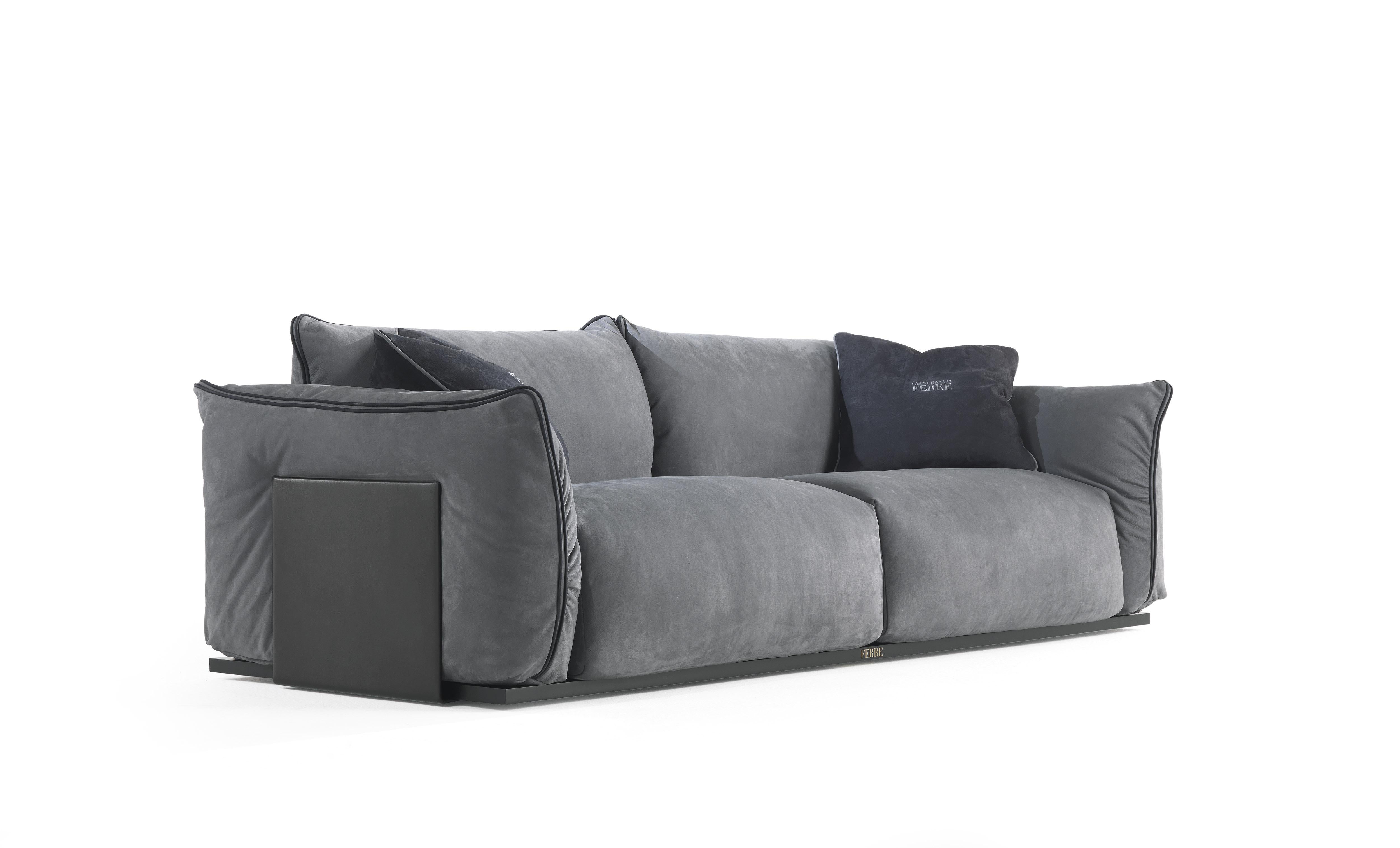 An attractive sofa with a comfortable seat and a contemporary design. The geometric volumes are emphasized by the external plates in metal upholstered leather and by the piping enhancing the profiles of the cushions. The use of leather as privileged