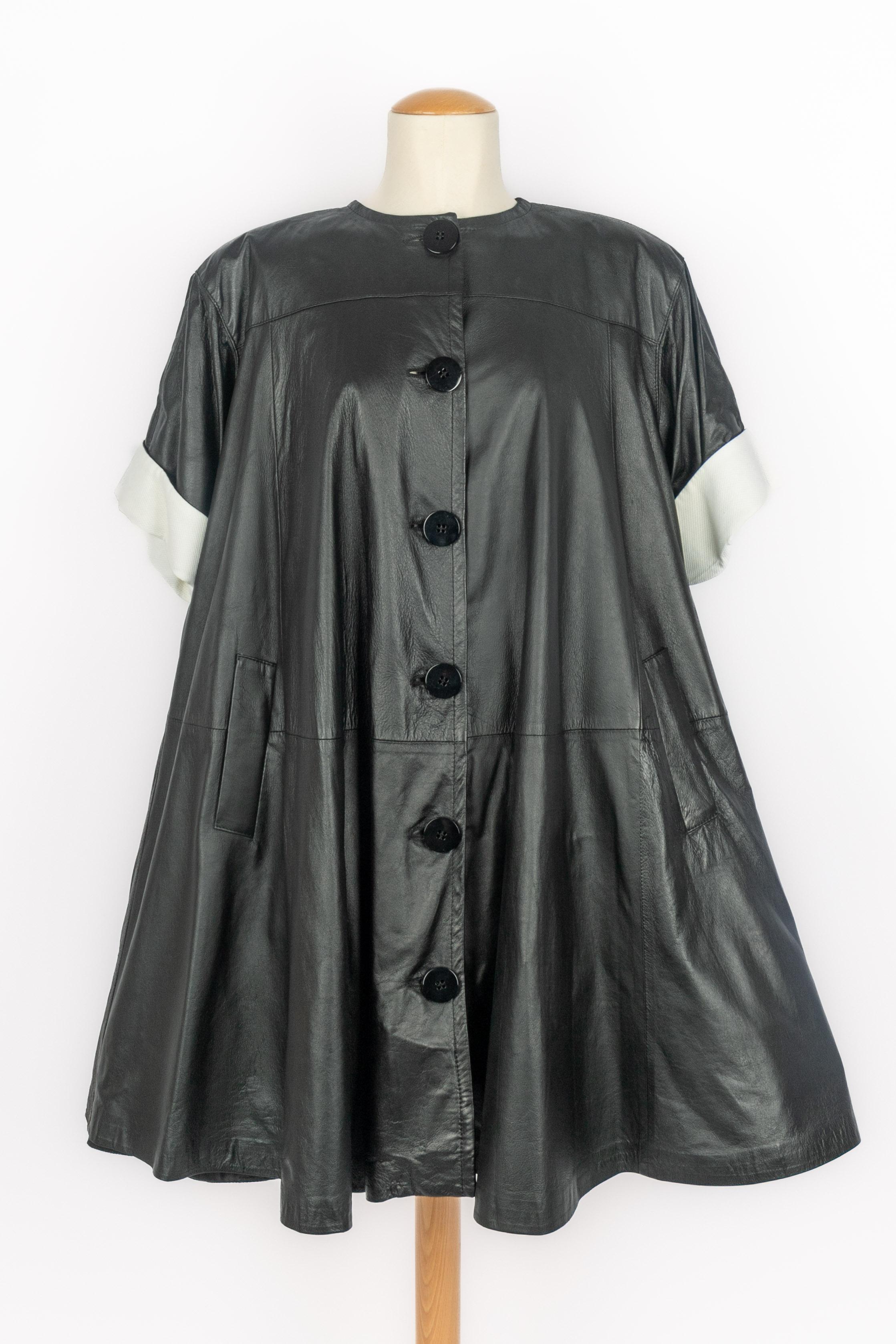 GIANFRANCO FERRÉ - (Made in Italy) Cappotto di media lunghezza in pelle nera, maniche corte con revers in cotone bianco, sottoveste in crine di cavallo. Non è indicata la taglia, si adatta a una 36FR/38FR/40FR. Collezione primavera-estate