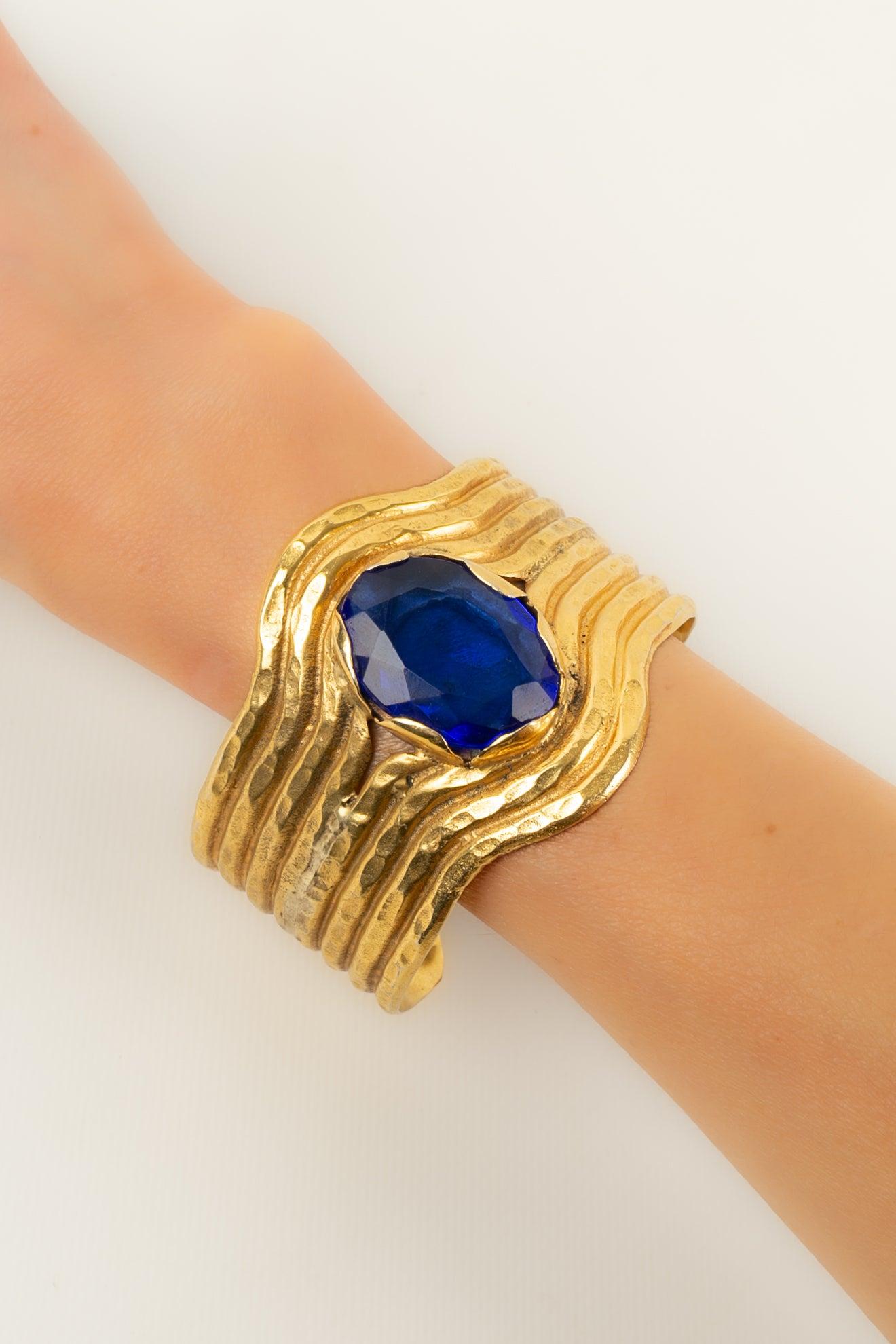 Gianfranco Ferré - (Made in Italy) Bracelet en métal doré surmonté d'un imposant strass bleu.

Informations complémentaires :
Condit : Très bon état.
Dimensions : Longueur : 17 cm

Référence du vendeur : BRA181
