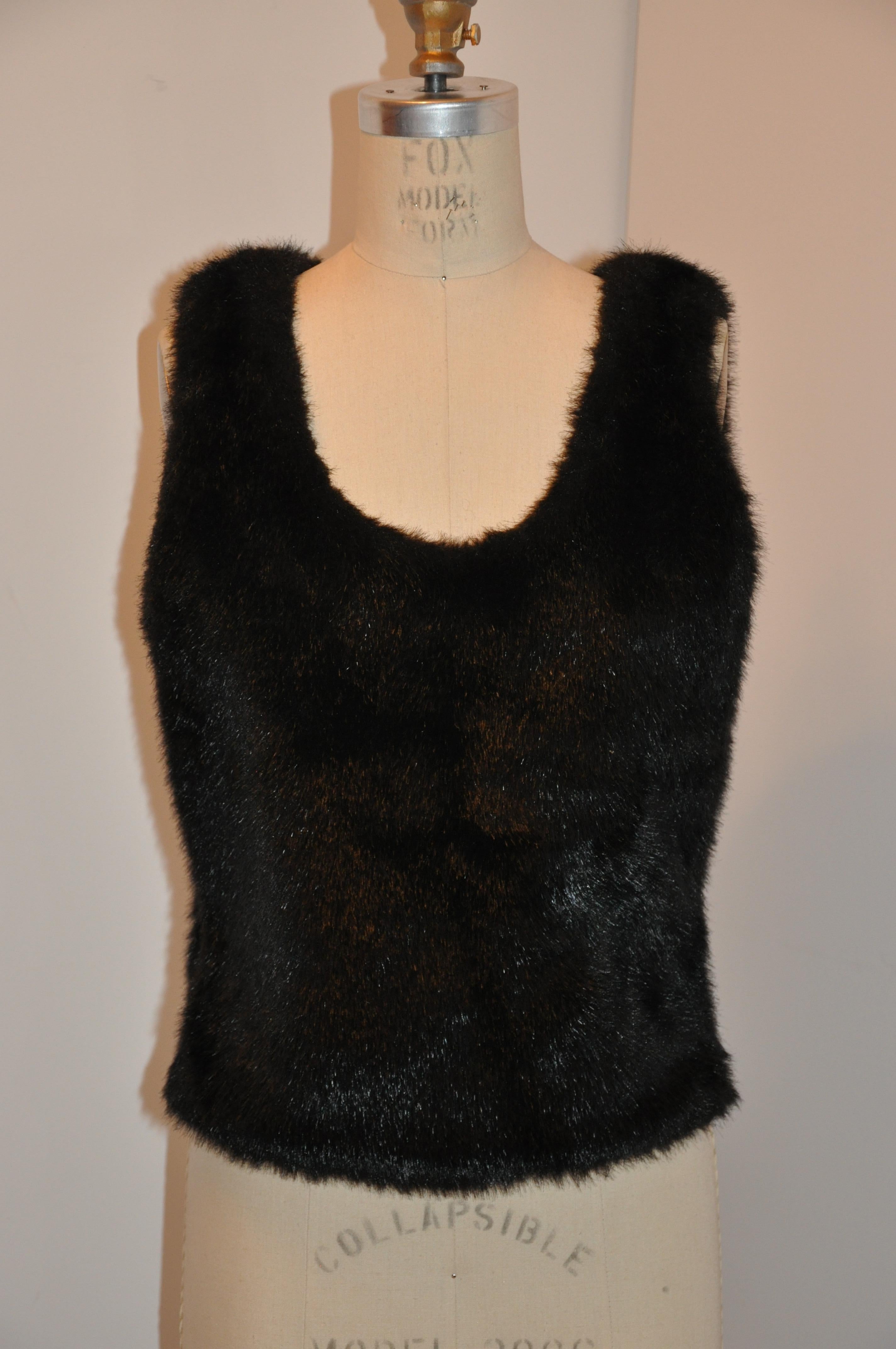    Gianfranco Ferre fully-lined black faux fur pullover is detailed with an invisible side zipper along the spandex side. Totaal length measures 22 inches. The underarm circumference measures 38 to 40  inches with the stretch spandex in mind. Waist