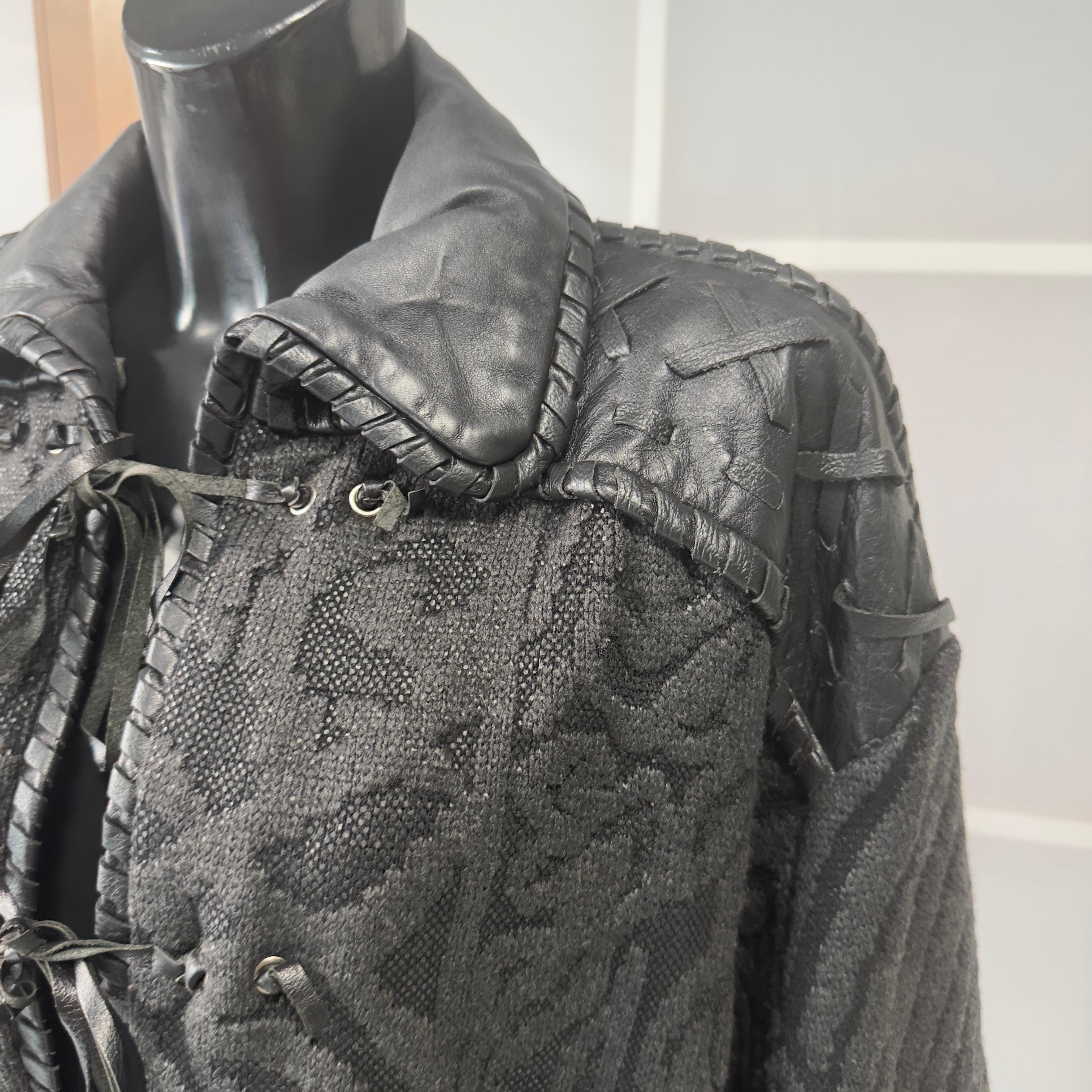A rare and sophisticated garment by Gianfranco Ferré, a symbol of the architectural elegance and bold design that have made the Italian designer famous. This vintage jacket in black jacquard fabric is enhanced by black genuine leather inserts, which