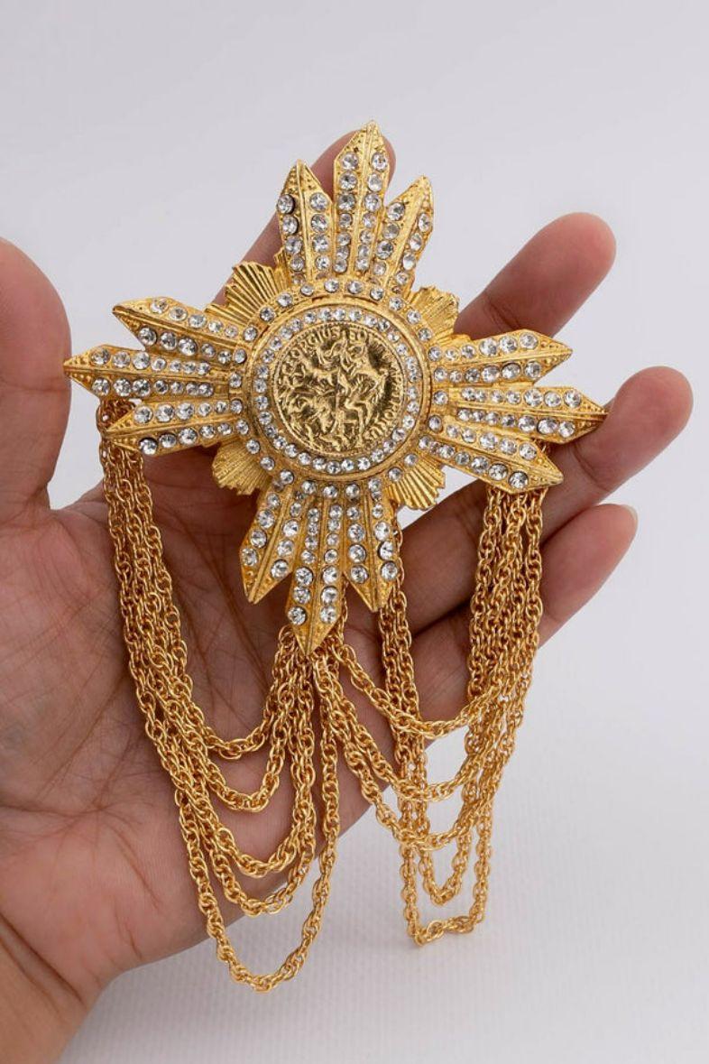 Ferre (Made in Italy) Gilted metal brooch set with rhinestones and made of chains.

Additional information:
Dimensions: Width: 8 cm (3.15 in) - Length with chains: 15 cm (5.9 in)
Condition: Very good condition
Seller Ref number: BR58