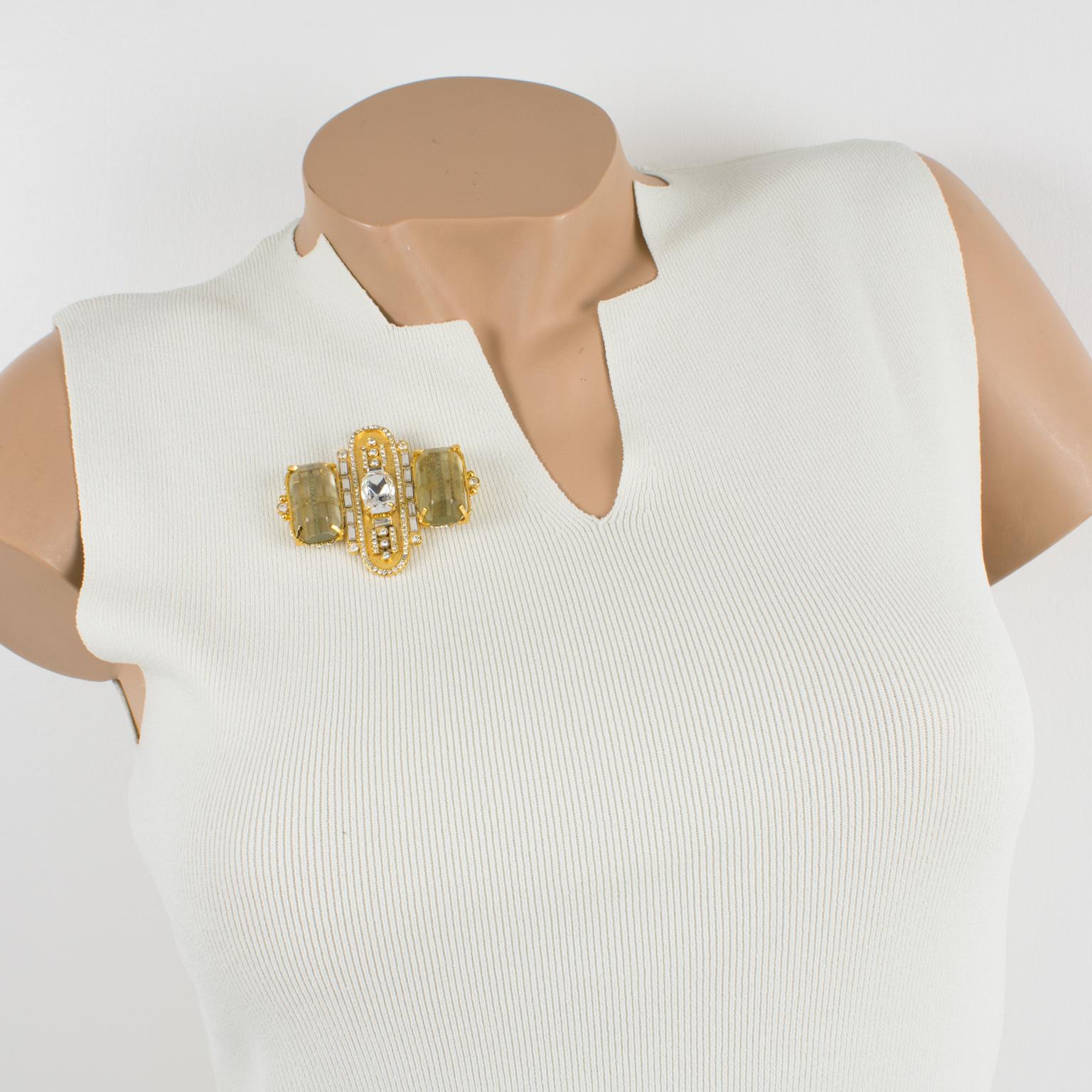 This stunning Gianfranco Ferre couture brooch features a dimensional gilt metal geometric framing paved with crystal clear rhinestones and topped with two massive champagne resin cabochons. On the underside, there is a security closing clasp with