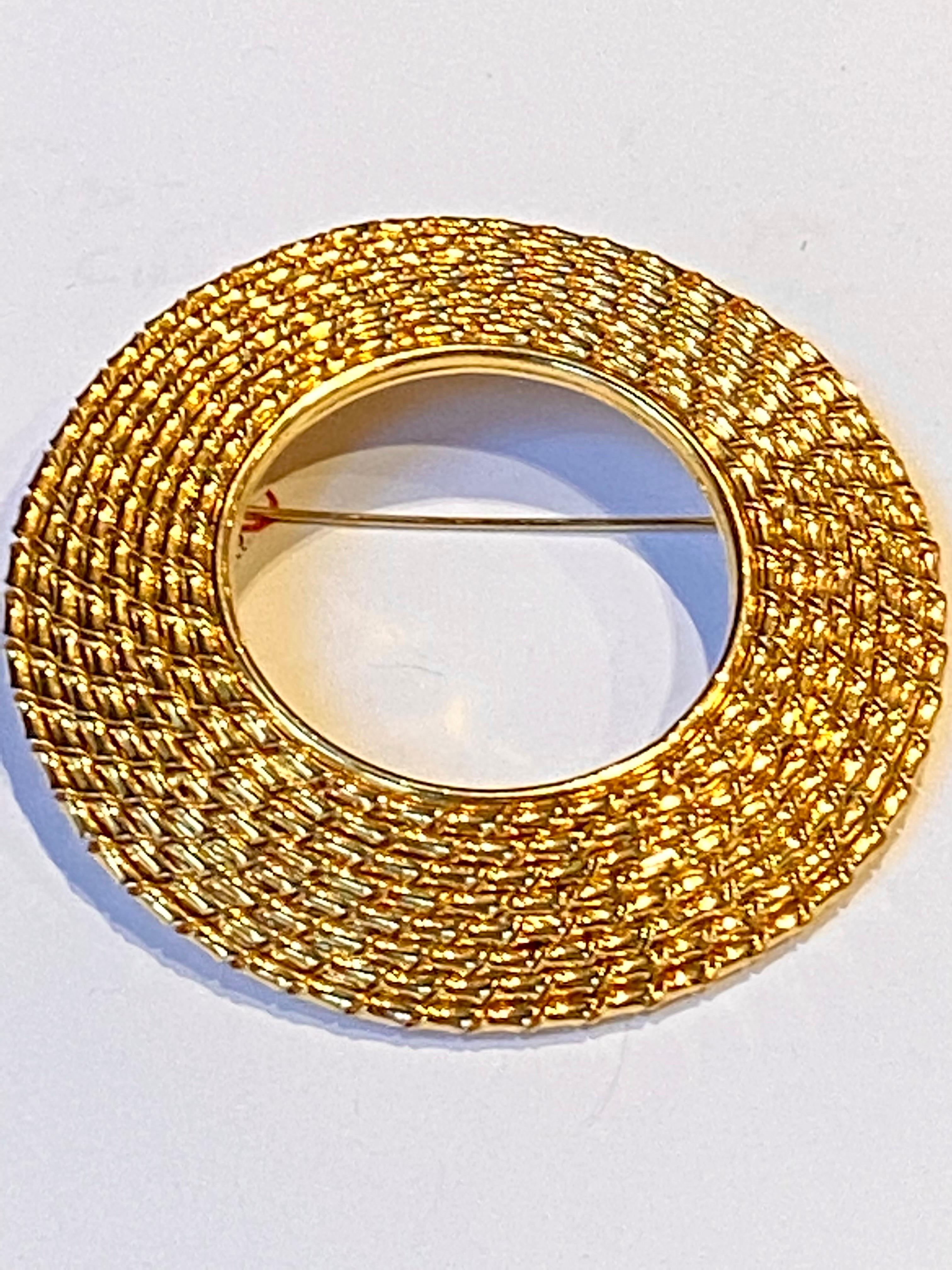 
The sun, the moon and the circle of life all symbolized by the circle. A classic shape as executed here by fashion designer Gianfranco Ferre in the 1980s. This circle pin is 3 inches in diameter. The 18K gold plate lightly domed ring is .75 of an